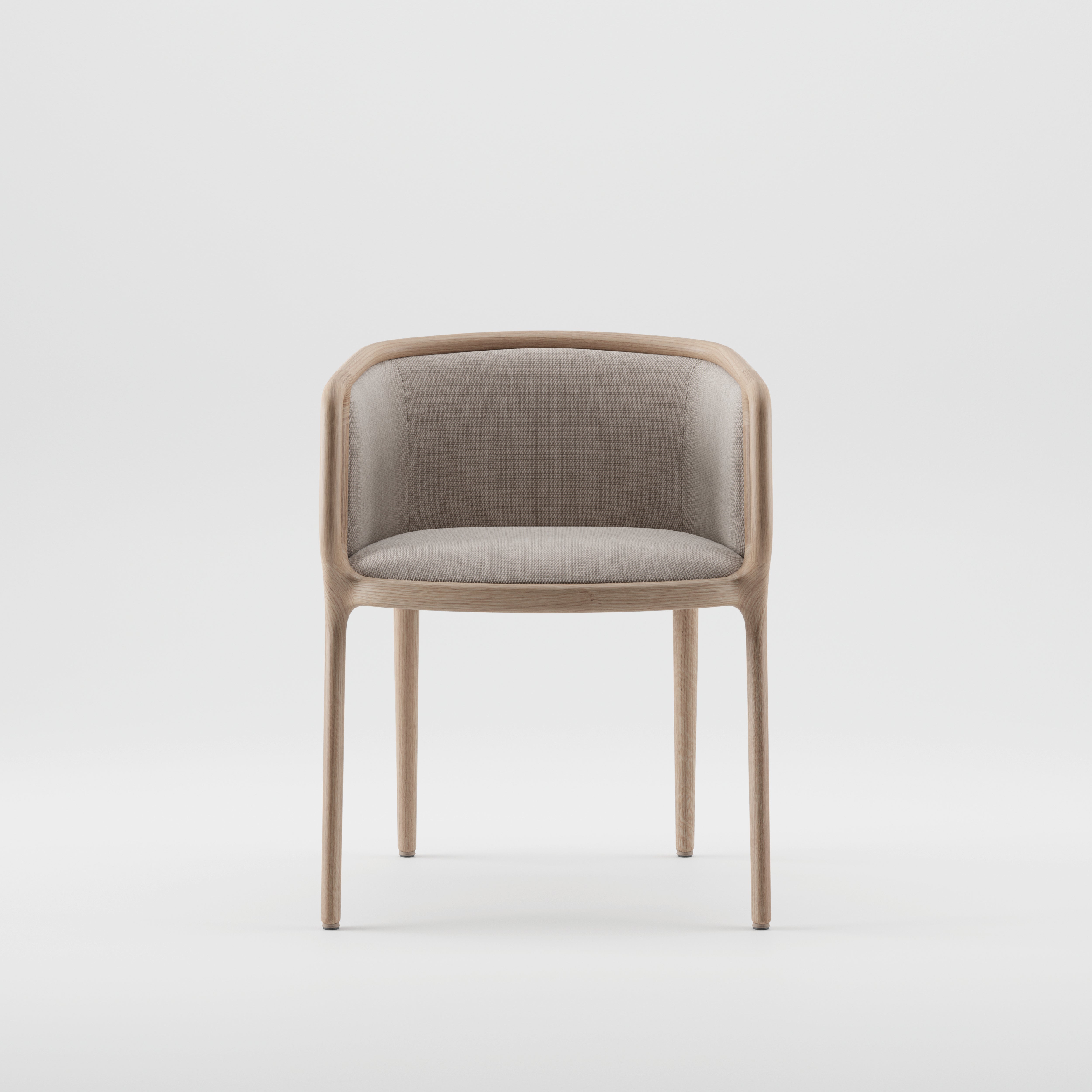 The VELO Chair by Artisan boasts a minimalist design with a light brown wooden frame showcasing natural texture. Its beige upholstered seat and backrest feature a curved back flowing into armrests, supported by four slender legs made from eco-friendly materials, all set against a plain white background.