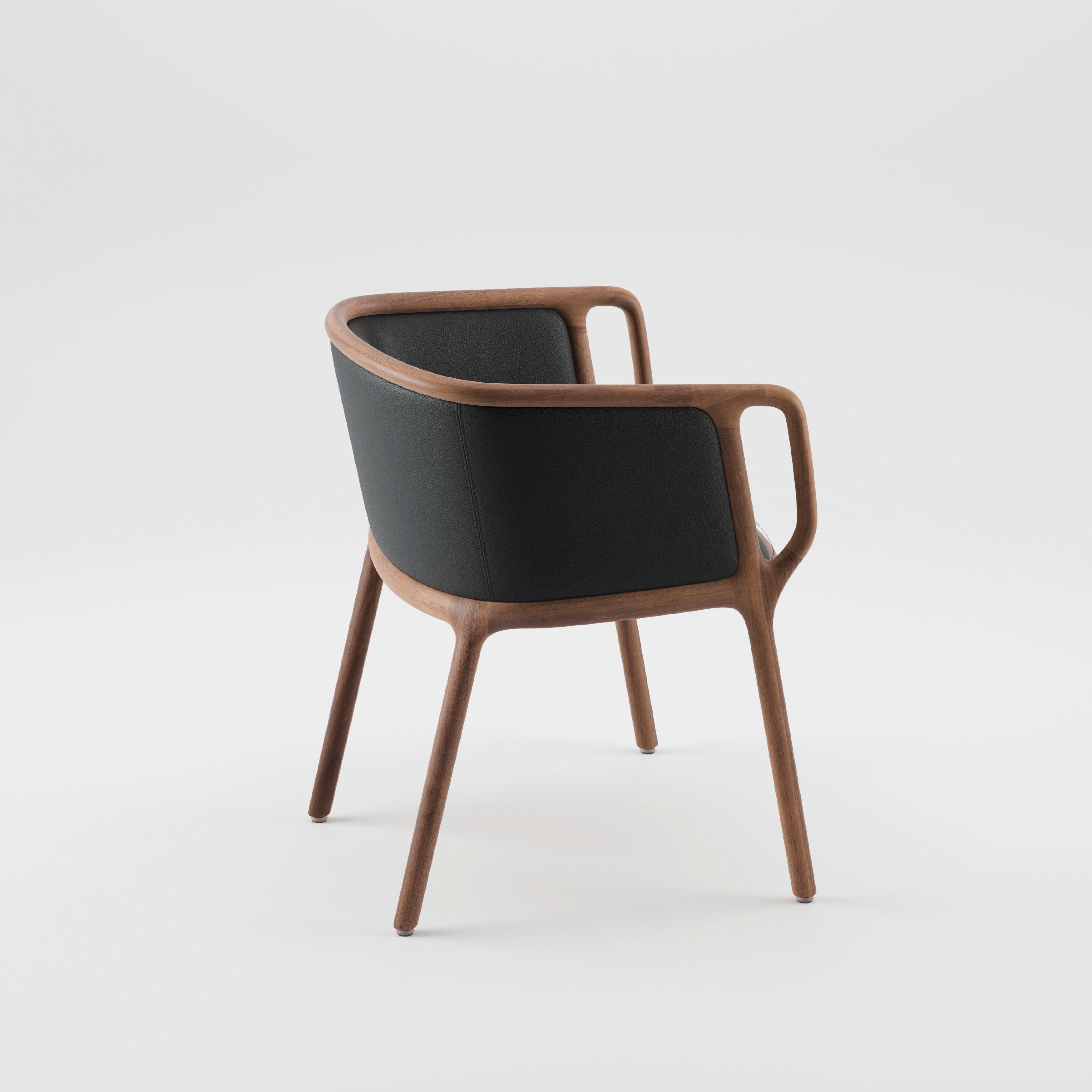 The VELO Chair by Artisan features a modern design with a smooth, solid wood frame finished in natural oils. It boasts a black cushioned backrest and seat, rounded edges, and minimalist lines against a plain white background.