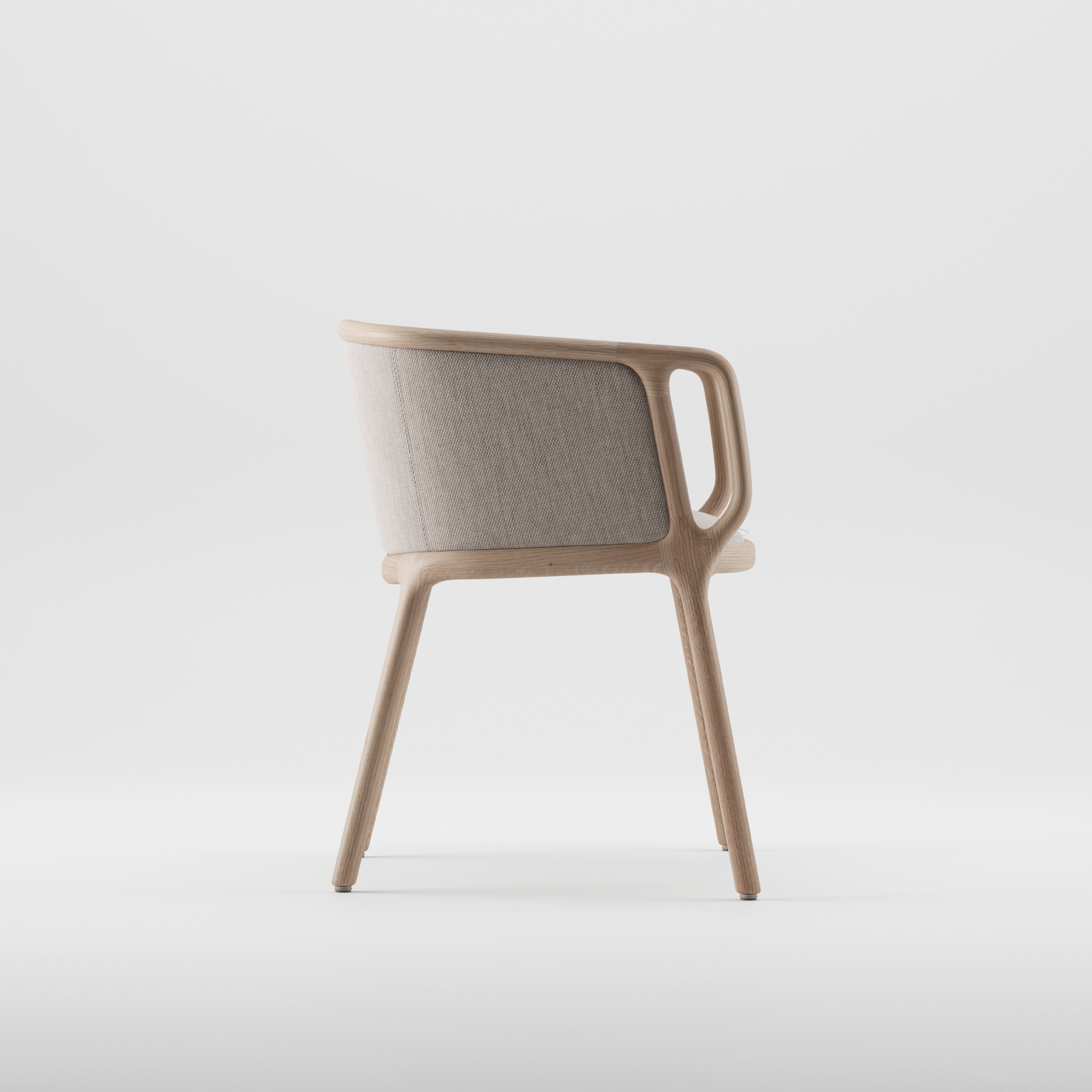 The VELO Chair by Artisan boasts a modern, minimalist design with a curved back. It features a light wooden frame made from solid wood and a soft, light beige fabric backrest. Its eco-friendly aesthetic is enhanced against a plain white background.