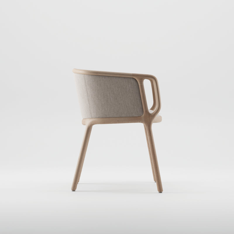 The VELO Chair by Artisan boasts a modern, minimalist design with a curved back. It features a light wooden frame made from solid wood and a soft, light beige fabric backrest. Its eco-friendly aesthetic is enhanced against a plain white background.