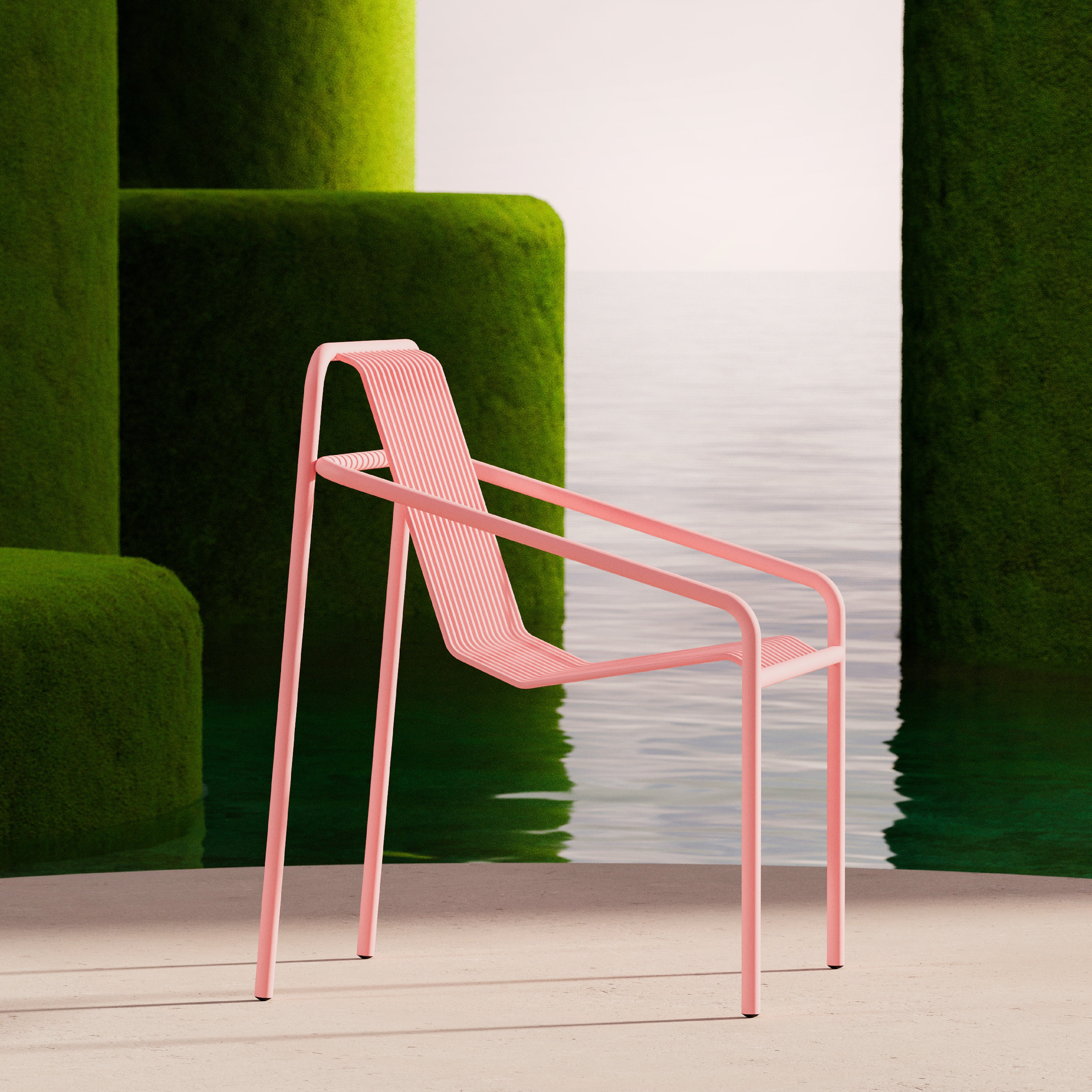 From the IVY outdoor collection by Objekte unserer Tage, this modernist pink chair is weather-resistant and minimalist. It rests on a flat surface next to tall, green mossy structures by water under an overcast sky.