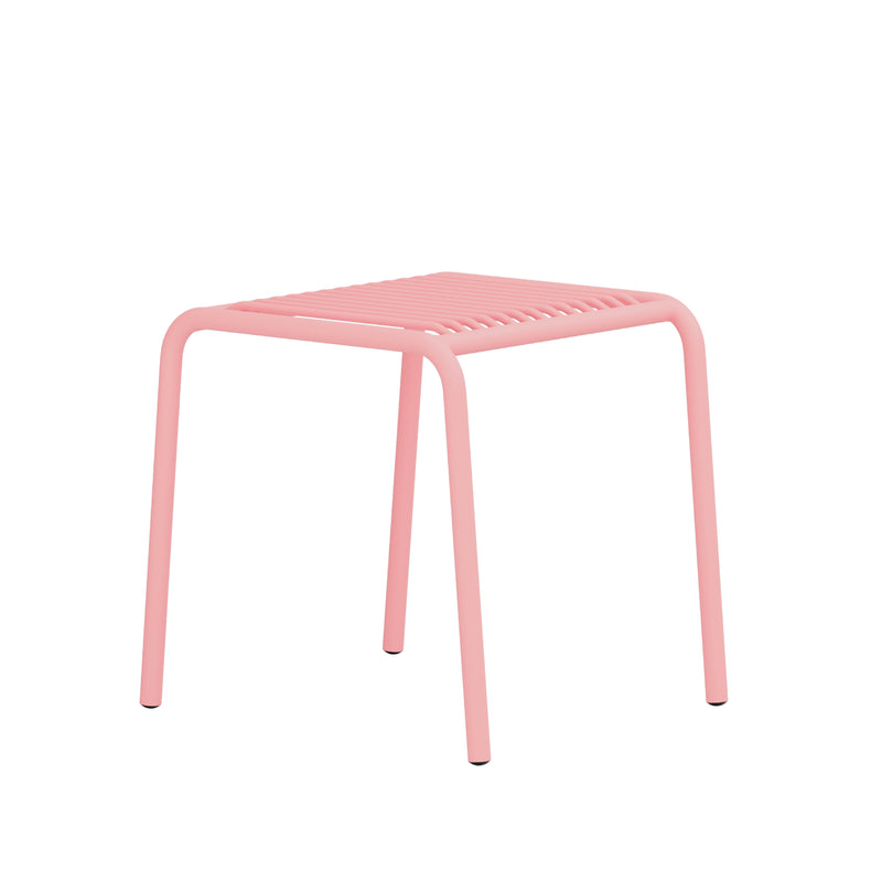 The IVY Outdoor Stool by Objekte unserer Tage is a minimalist pink metal stool with a ribbed seat and four curved legs, made from powder-coated steel. Its sleek design is perfect for modern outdoor spaces, shown against a white background.