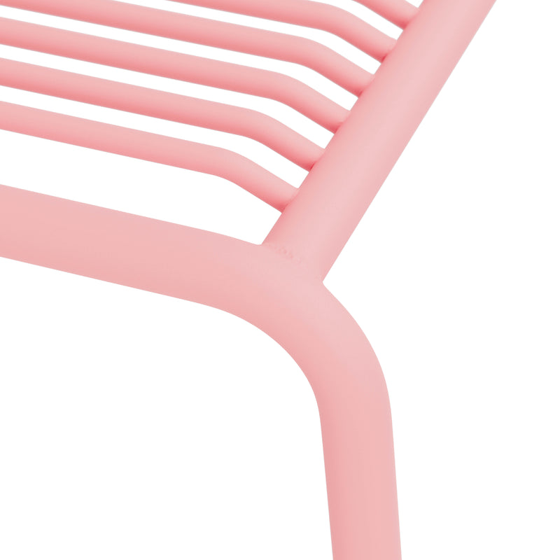 Close-up of Objekte unserer Tages IVY Outdoor Stool, showcasing the minimalist pink metal frame with a slatted seat made of powder-coated steel. Smooth, rounded corners and intersecting bars enhance its design, making it a perfect addition to any outdoor furniture collection.