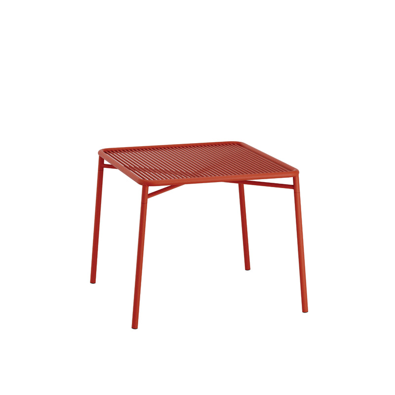The IVY Outdoor Table by Objekte unserer Tage features a minimalist design with a square slatted top and simple straight legs crafted from powder-coated steel, adding a modern touch to any outdoor collection.