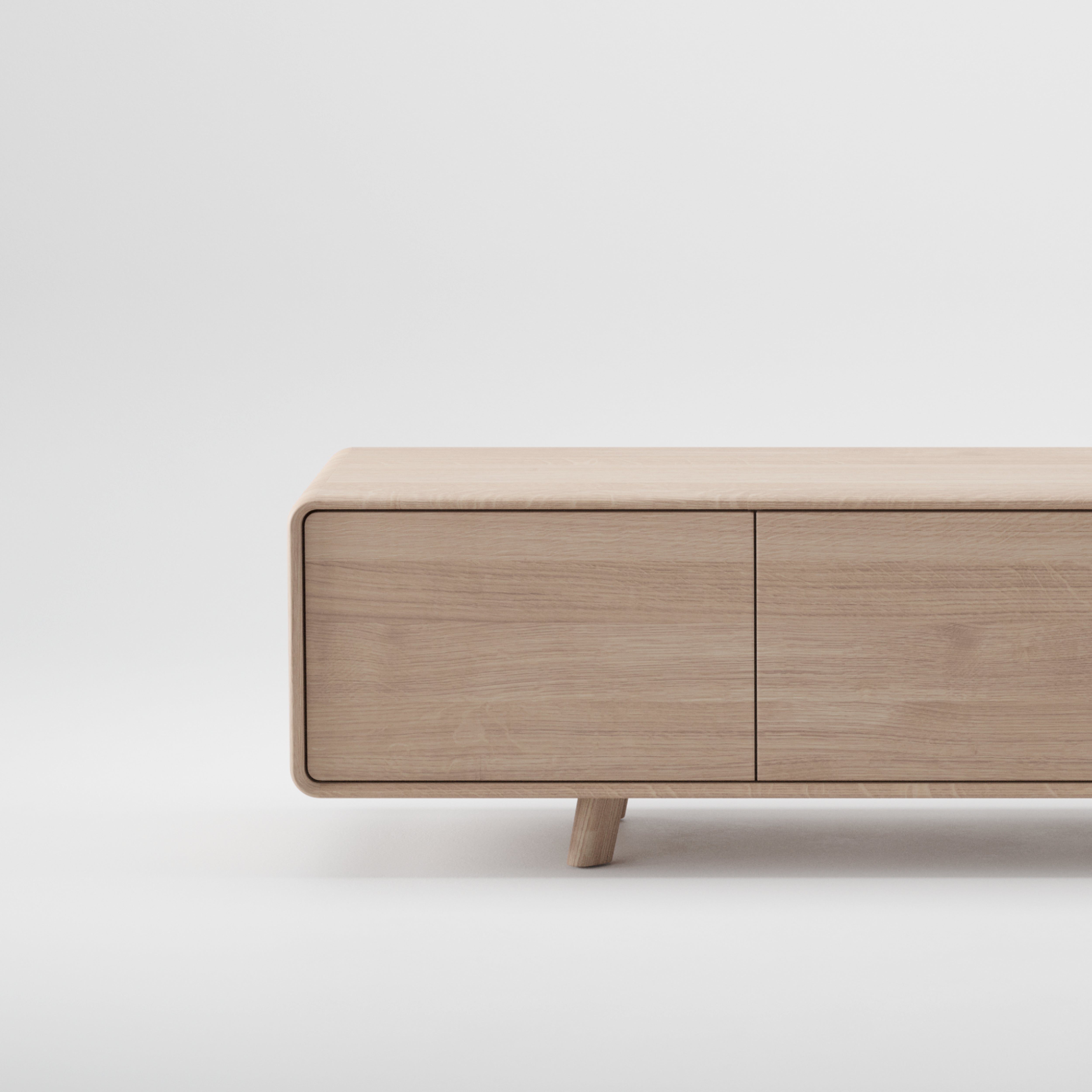 The NEVA Lowboard by Artisan is a minimalist bench crafted from environmentally-friendly solid wood with a light natural finish. Featuring a smooth, flat surface, rounded edges, and short tapered legs on a white background, it exudes sustainable elegance.