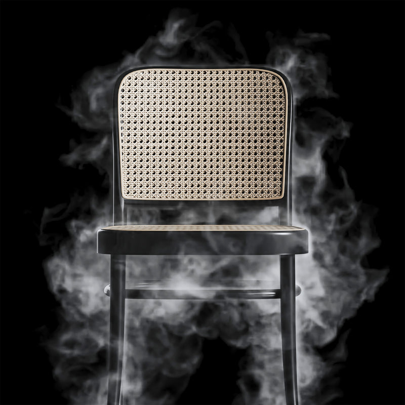 Chair 811 - Cane, a black wooden chair with cane seating and backrest surrounded by smoke on a black background.