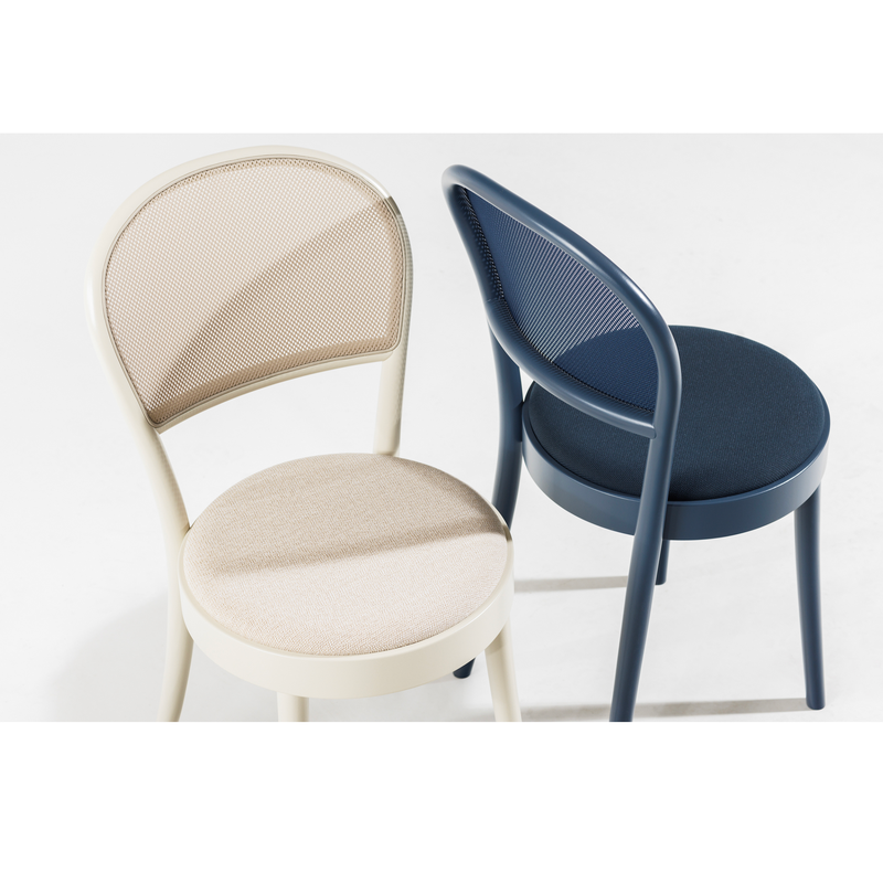 Viewed from above on a white floor, one chair is cream with a round seat and mesh backrest, while the other is navy blue. Both chairs exemplify contemporary design and bentwood craftsmanship, evoking the modern minimalist style of the iconic TON Chair 314-Upholstered by TON.