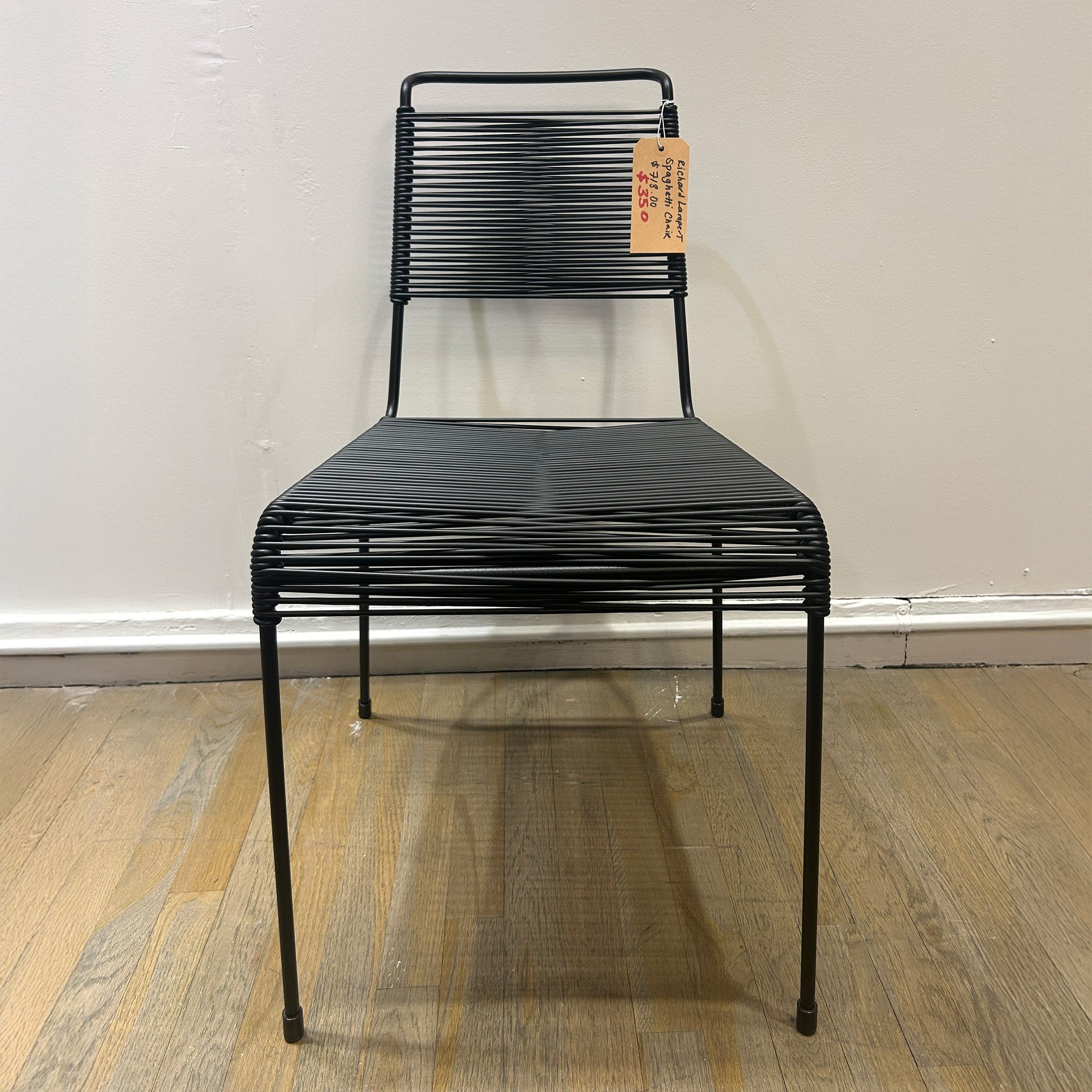TT54 Spaghetti chair with black steel rod frame and plastic string seat and backrest, modern minimalist design.