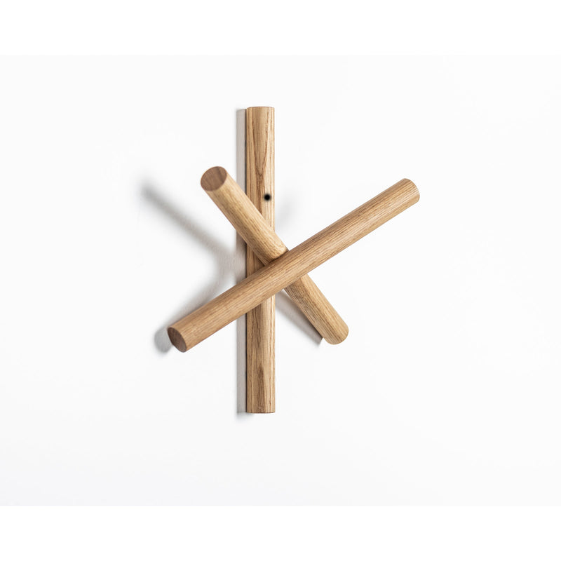 The TON Logs - Inventory is a minimalist coat hook crafted from quality wood offcuts, featuring three cylindrical pegs in an asymmetrical design on a white wall. It embraces sustainable design and arrives in recycled packaging for an eco-friendly touch.