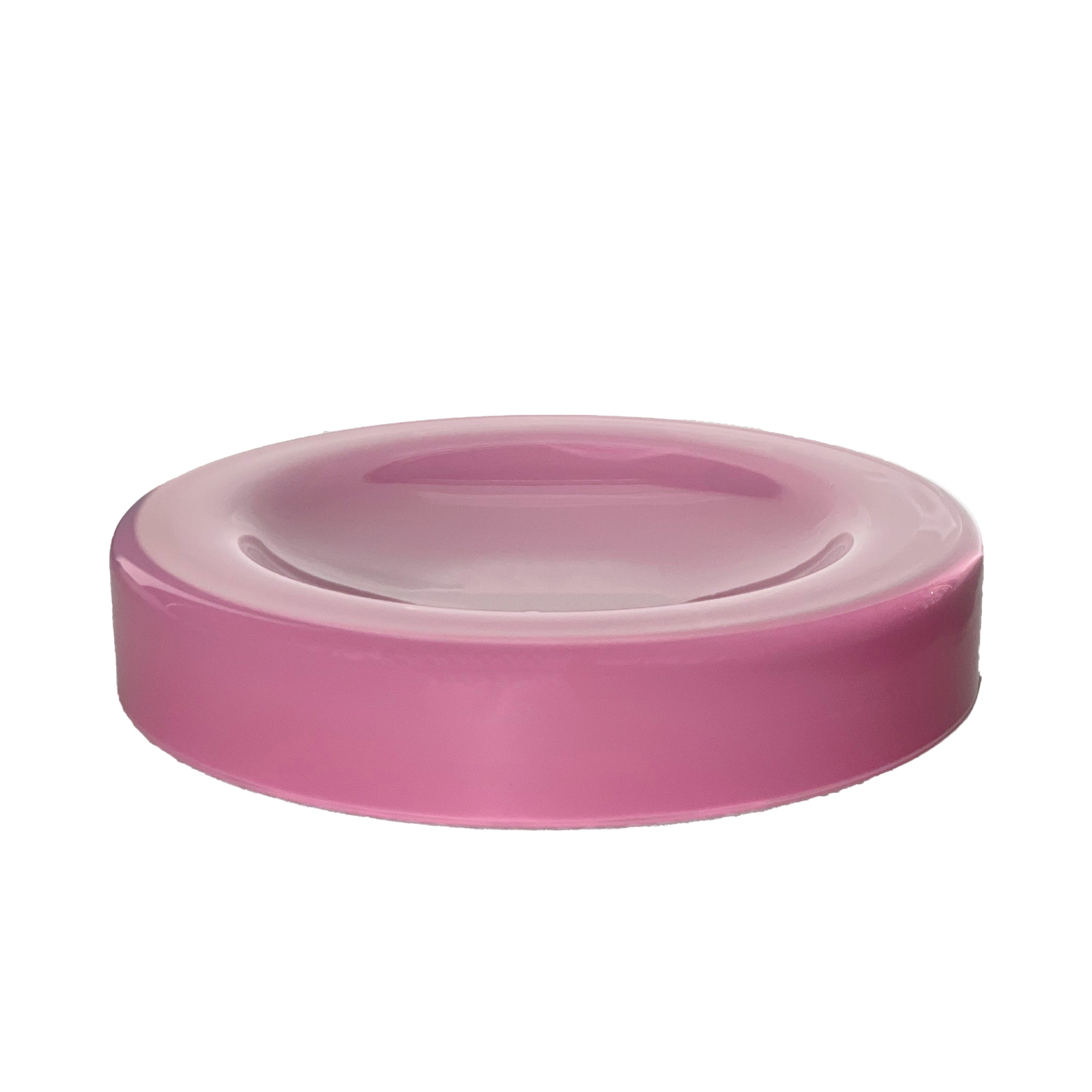 A round, pink ceramic WET Bowl Big by Ursula Futura with a slightly raised edge is centered against a white backdrop. Its glossy finish adds surface tension, giving it an elegant touch like mouth-blown glass.