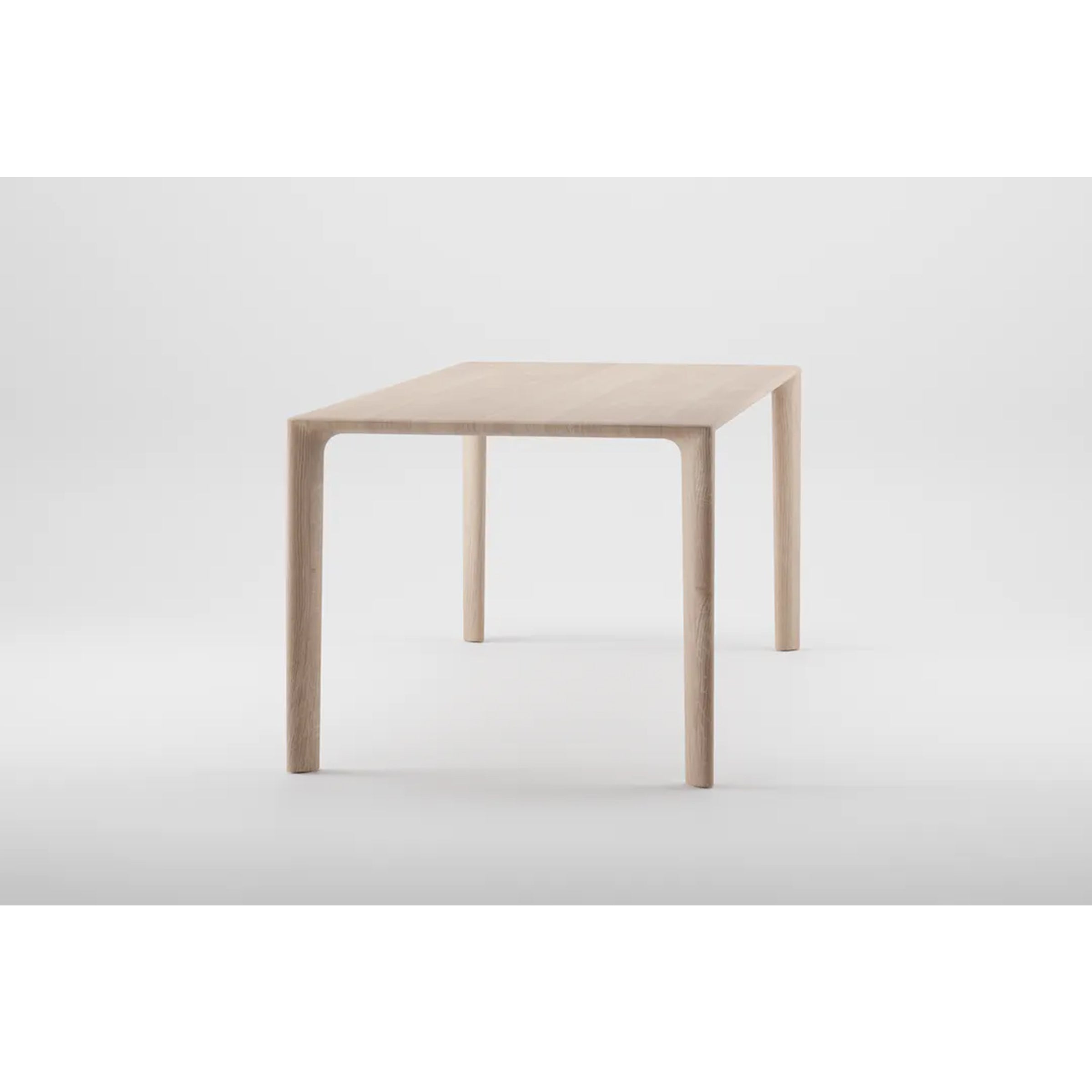 The MELA Table by Artisan is a minimalist piece crafted from solid wood, featuring a rectangular top, four straight legs, and a natural oil finish for an eco-friendly touch, presented against a plain white background.