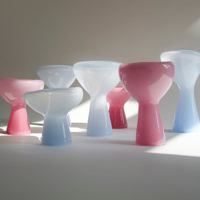 Ursula Futuras PHANTOM Dish features mouth-blown glass sculptures in white, pink, and light blue. Reminiscent of oversized chess pieces with bulbous shapes, their glossy design casts soft shadows on pristine surfaces under natural light.