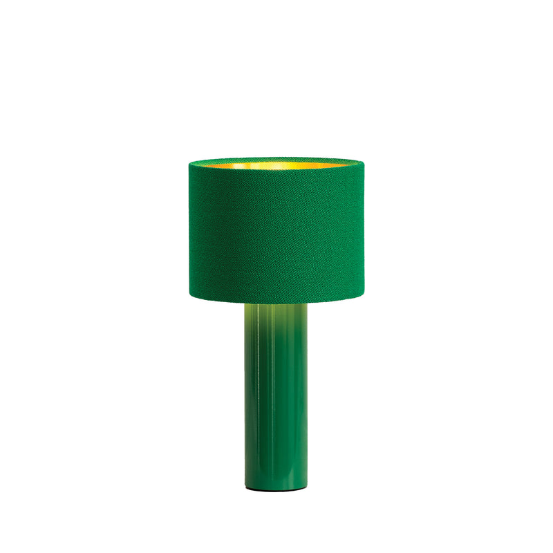 The ALL ROUND MINI Table Lamp by Victor Foxtrot is a modern green lamp with a cylindrical base and wool fabric shade that emits a warm yellow light, offering a gentle glow that softly contrasts its cool green design.