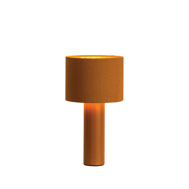 The Victor Foxtrot ALL ROUND MINI Table Lamp boasts a contemporary cylindrical design with a warm orange wool fabric lampshade and matching base. Isolated on a white background, it emits a soft, cozy glow.