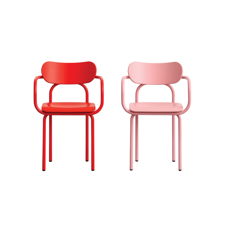 The Double U Armchair by Victor Foxtrot features two modern chairs with tubular steel frames, one in bright red and another in light pink, both with curved backrests and armrests, set against a plain white background.