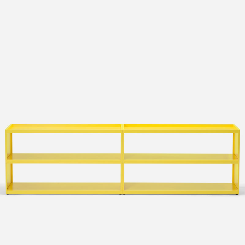 The W1 Stack Shelves by Loehr is a modern, bright yellow shelf with a minimalist design, featuring two spacious rectangular sections and four tiers. Its sleek structure stands out against a plain white backdrop, highlighting its vibrant color.