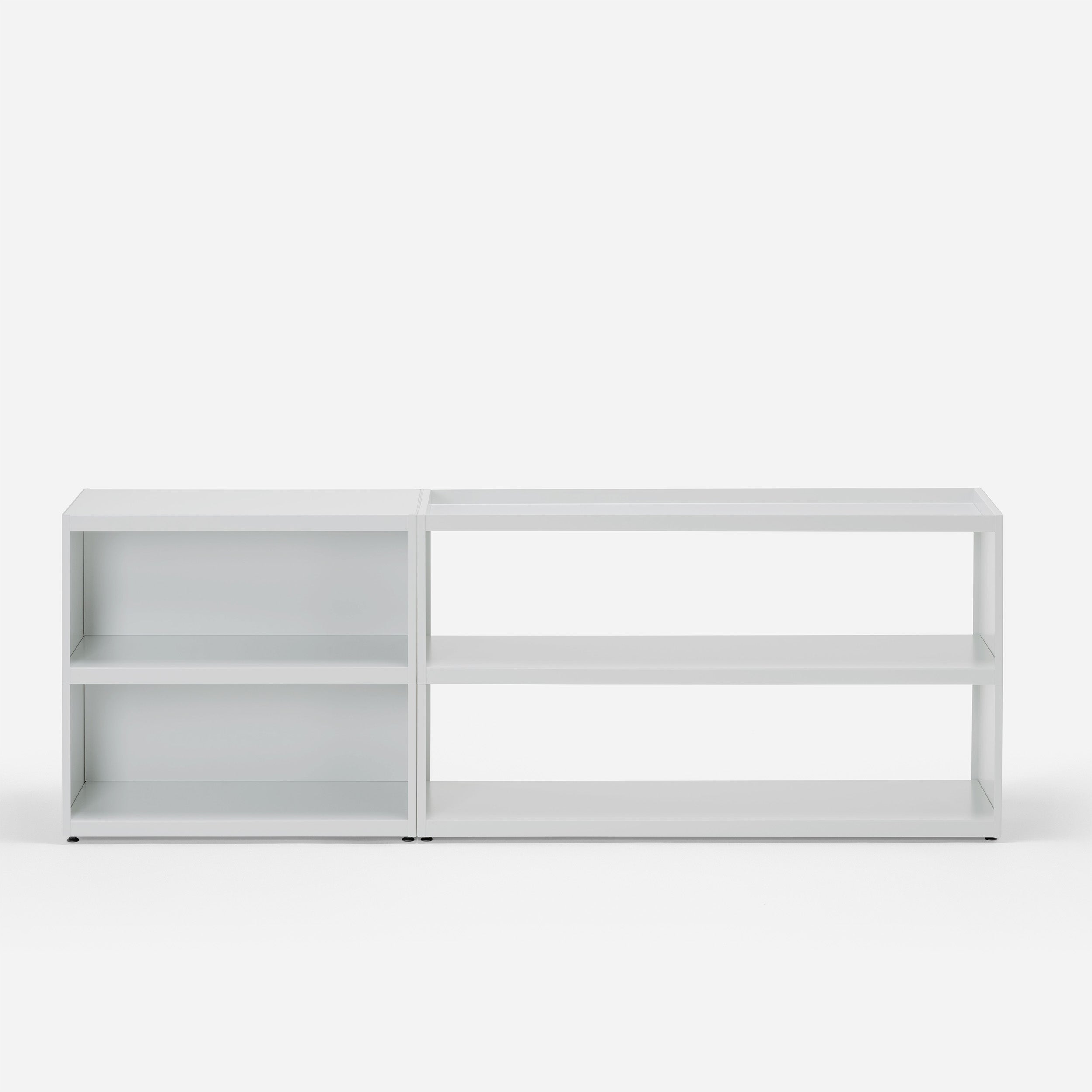 The Loehr W1 Stack Shelves offer a modular, minimalist storage solution with a grid structure and two sections of open shelves, forming four rectangular compartments. Its simple design seamlessly blends with any minimalist aesthetic against a plain background.