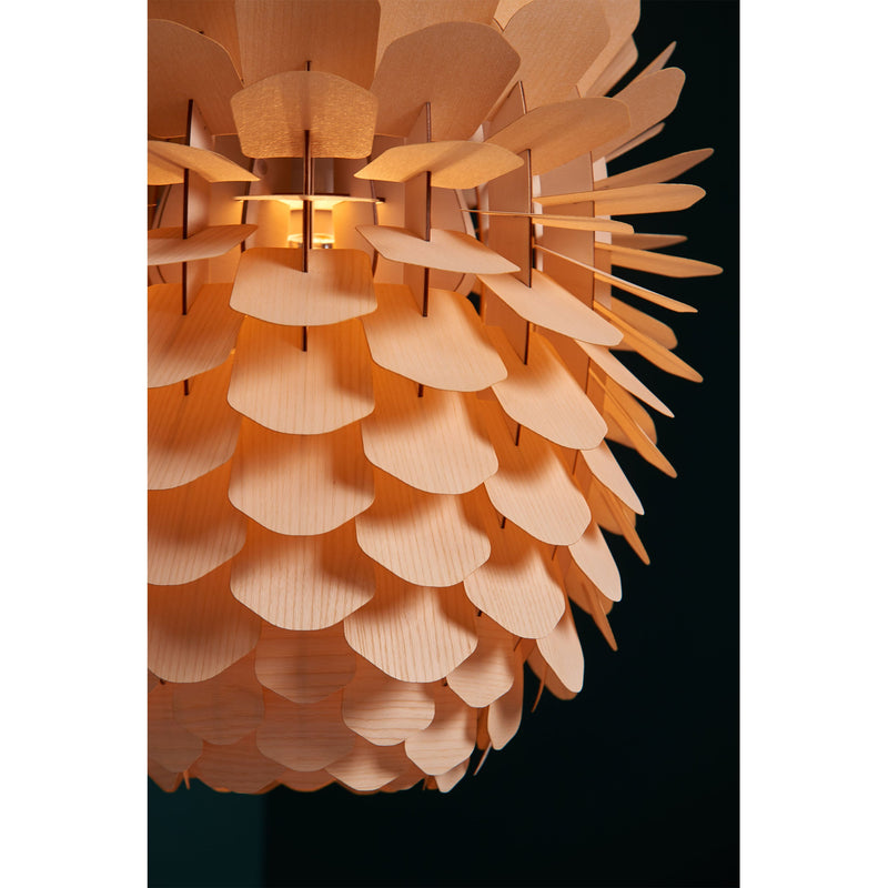 The ZAPPY ASH lamp by Schneid is a handmade wooden fixture crafted from ash or oak veneer, featuring layered, petal-like pieces that form a spherical shape and emit a warm, soft glow against dark backgrounds.