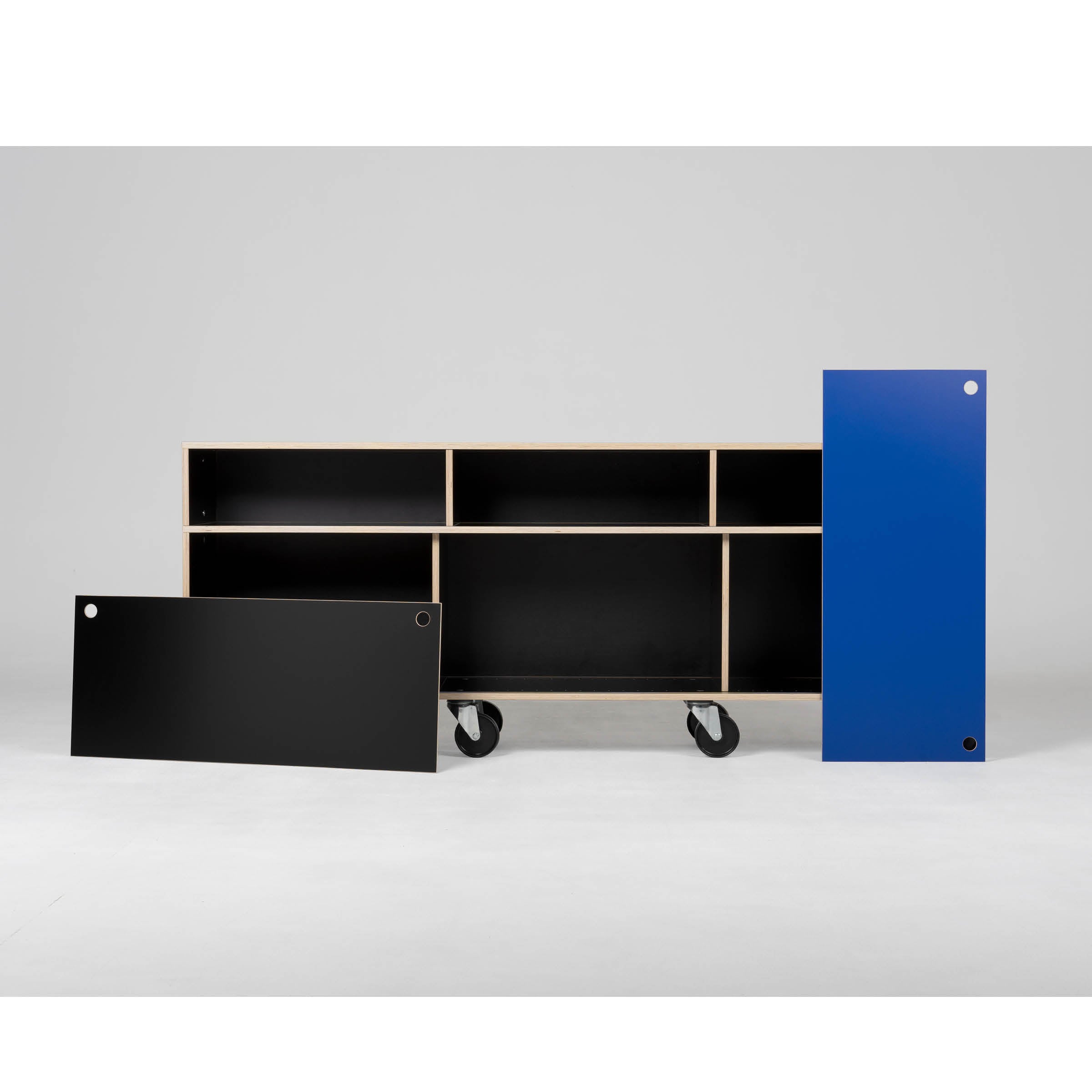 The Egal Rollboard by Moormann is a sleek, modern shelving unit on wheels featuring three black shelves and two separate panels—black and blue. With round corner cutouts, it combines the versatility of sideboards into a mobile design.
