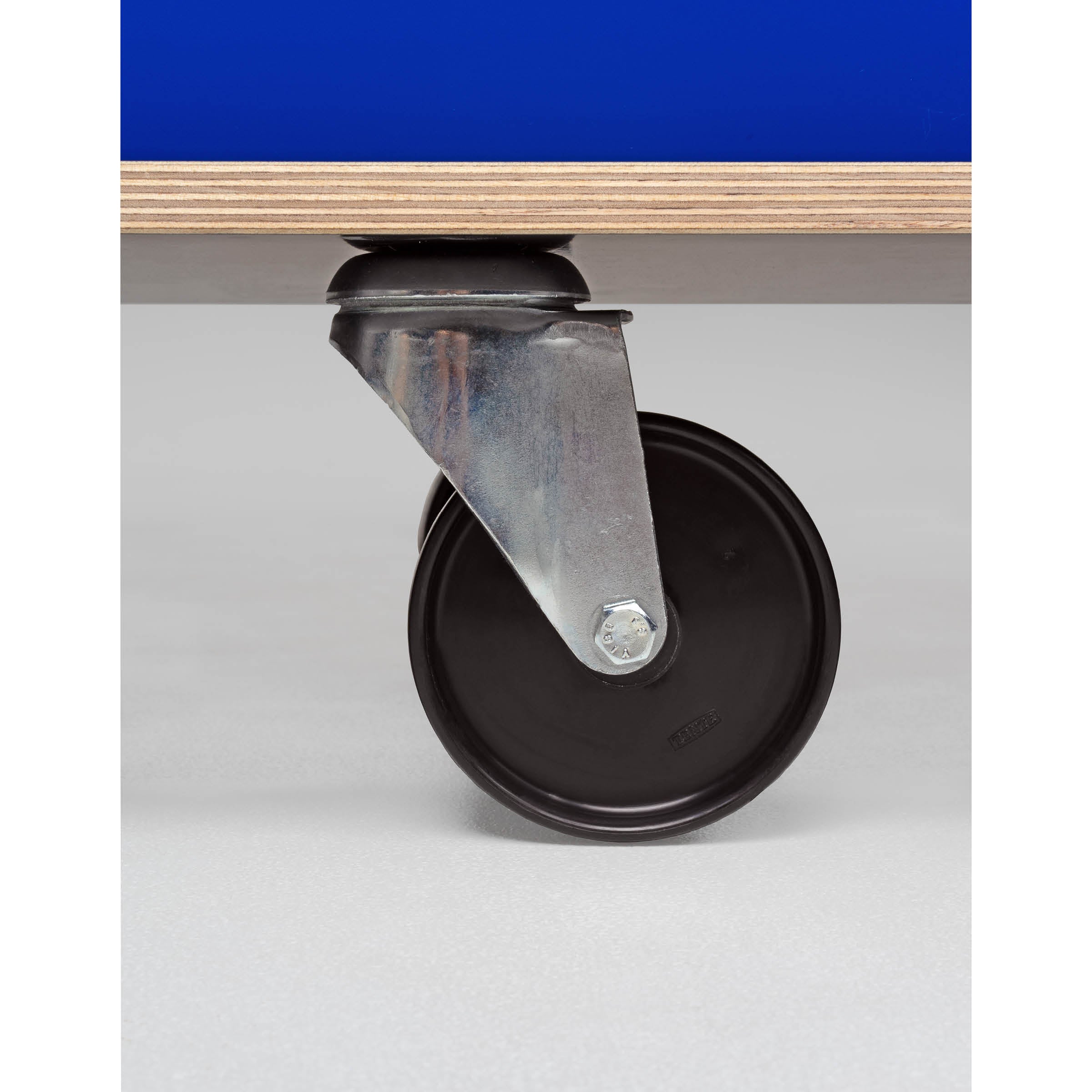 A close-up of a black wheeled caster with a silver bracket attached to the bottom of a blue-surfaced Moormann Egal Rollboard, set against a light gray background, ideal for sideboards with sliding doors.
