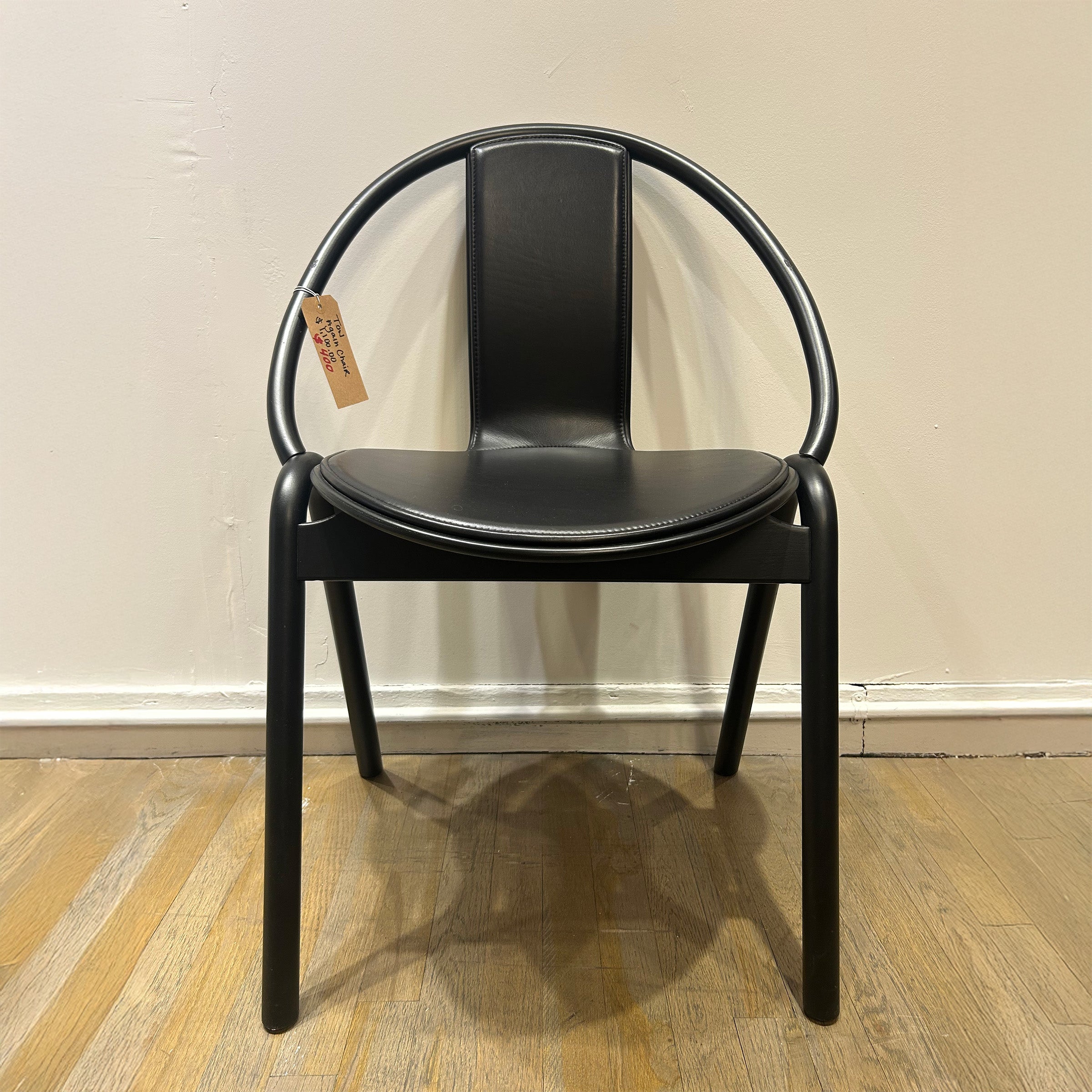 Chair Again - Sale: black bentwood chair with curved backrest and padded seat on wooden floor against beige wall.