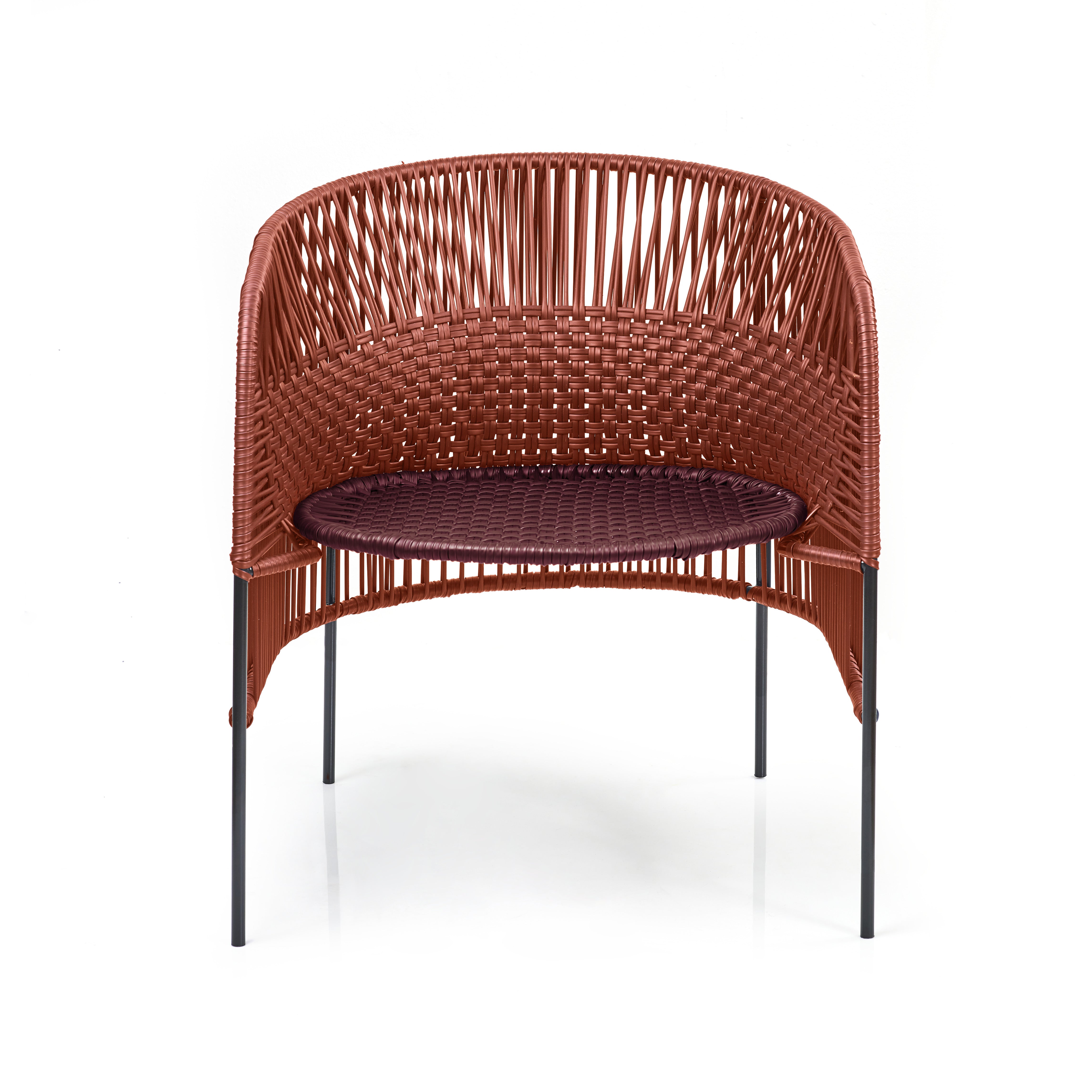 The Ames Caribe Chic Lounge Chair by Ames, designed by Sebastian Herkner, features a woven reddish-brown backrest and seat inspired by Colombian craft, with four slender black metal legs, set against a white background.