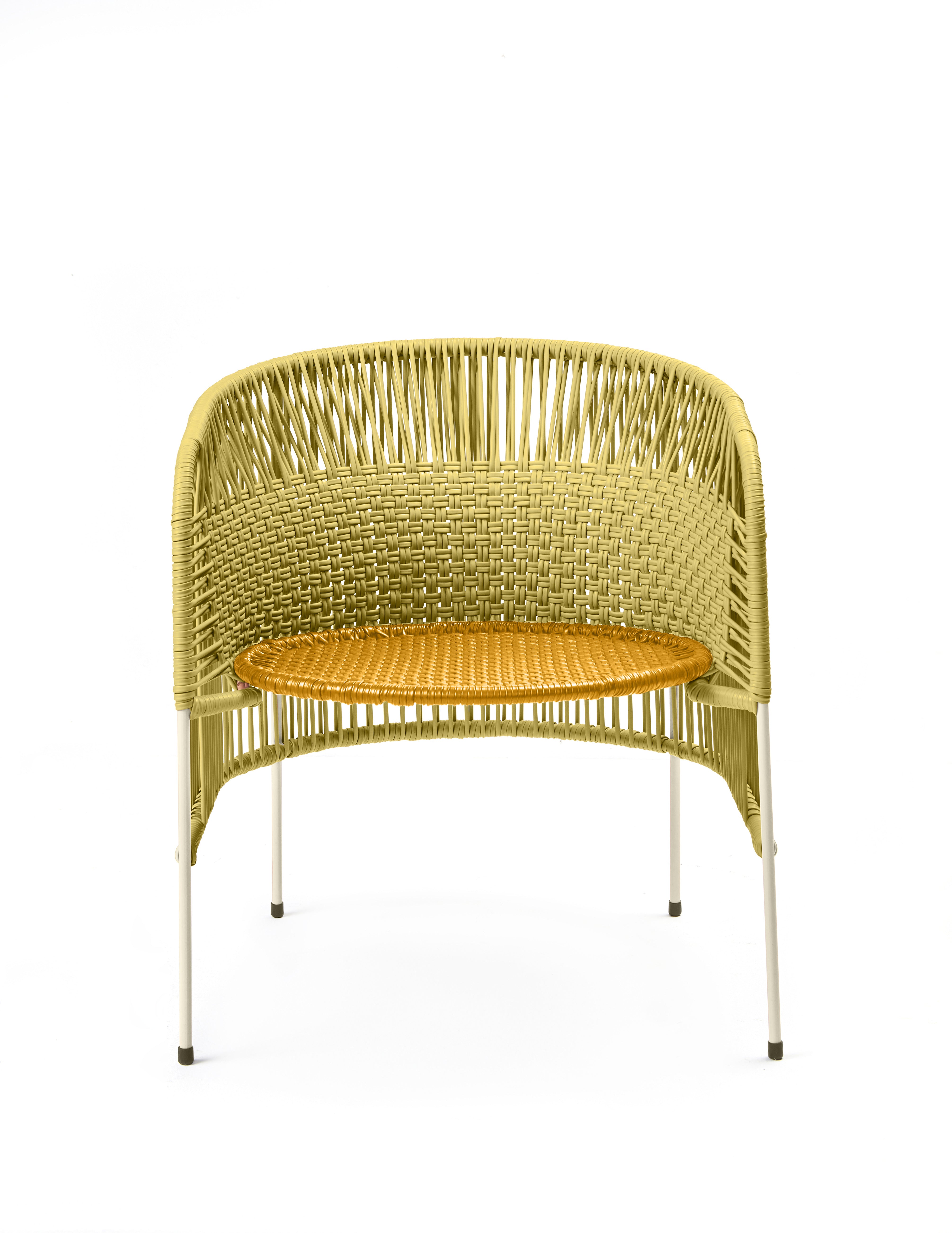 The Ames Caribe Chic Lounge Chair by Ames features a woven light yellow-green backrest and tan seat, crafted with Colombian weaving on slender white metal legs, designed by Sebastian Herkner.