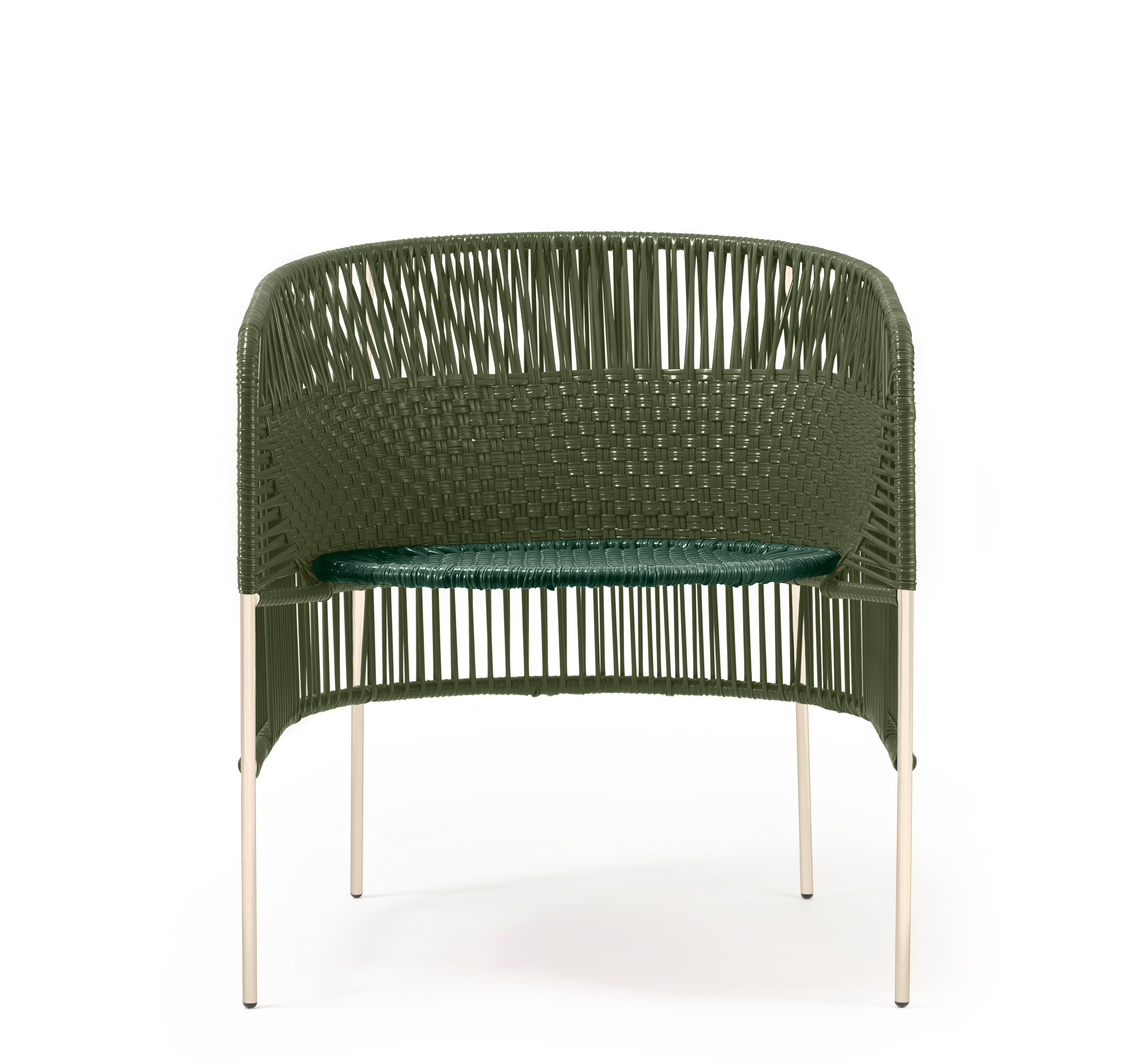 The Ames Caribe Chic Lounge Chair by Ames features a green woven design with a rounded backrest and seat on four slim, light-colored legs. Inspired by Colombian weaving crafts, it reflects Sebastian Herkner’s distinctive Caribe Chic series style. Plain white background.