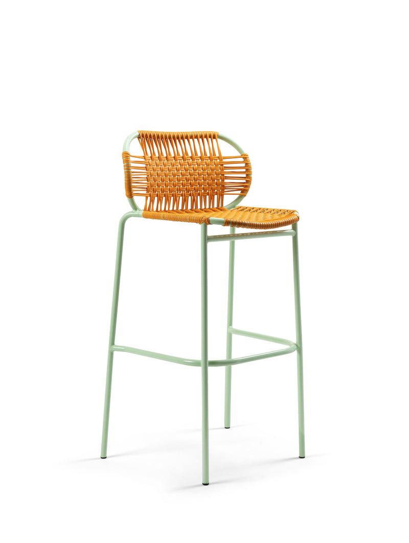 The Ames Cielo Barstool by Ames features a mint green metal frame with a woven rattan seat and backrest. This stackable barstool blends modern design and functionality, shown against a plain white background.