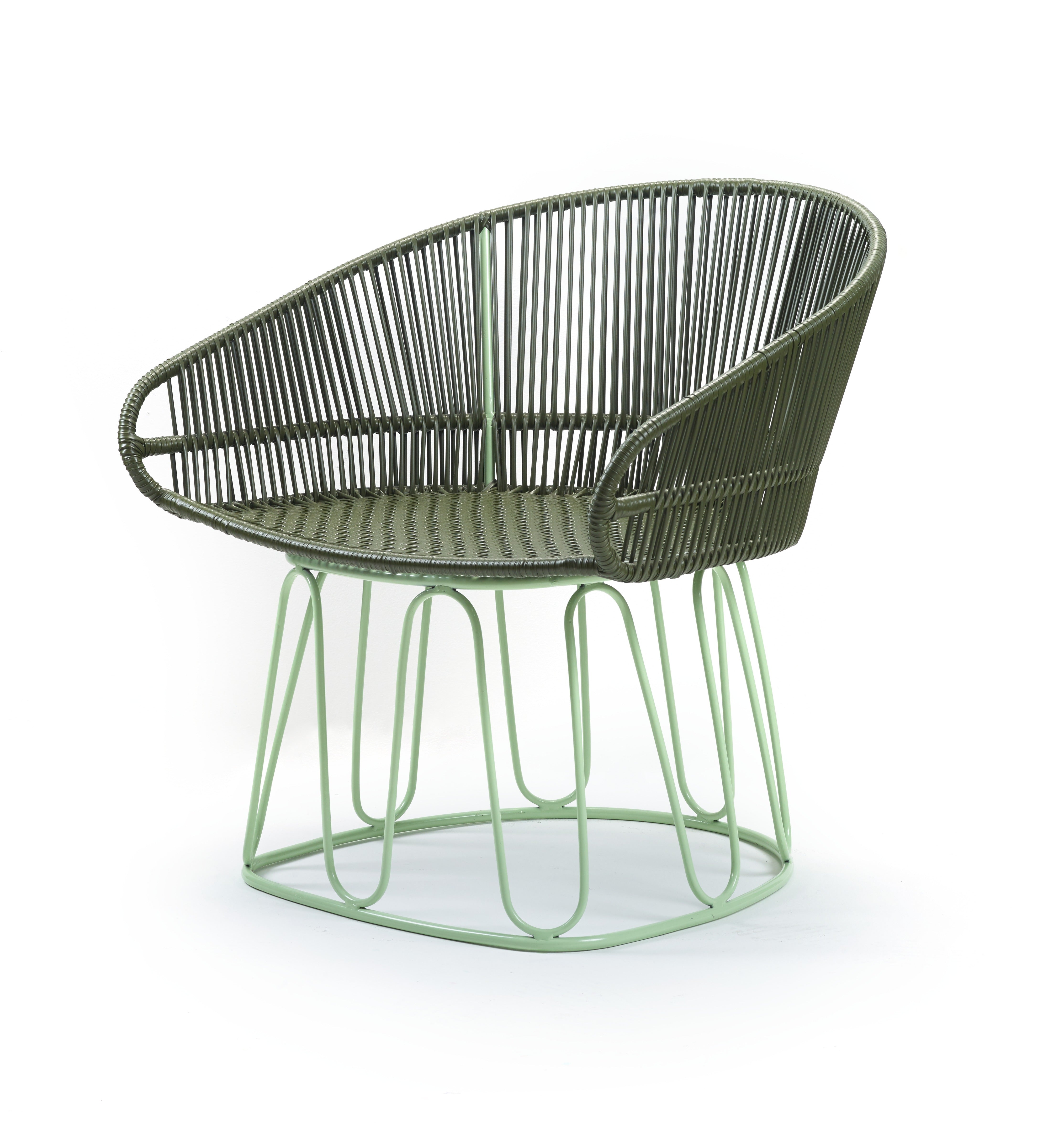 The Ames Circo Leather Lounge Chair by Ames features a modern, open, rounded design with an olive green woven rope seat and backrest on a light green metal wire base. This handcrafted Colombian piece is shown against a white background.