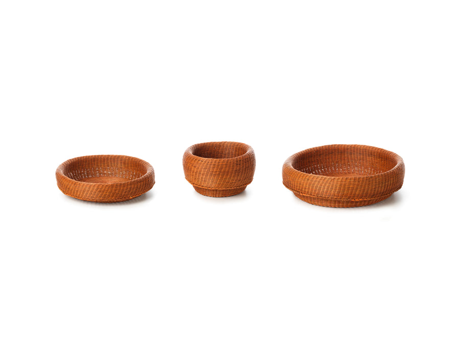 Three Ames Fibra Basket Large baskets by Ames, handcrafted in Colombia from esparto grass, are shown on a white background—the left and right are shallow and round, while the center is taller and cup-shaped.