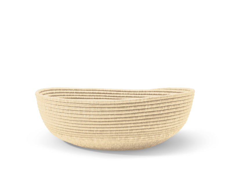 The Ames La Che Baskets by Ames are round, shallow, and beige, handcrafted with Fique fibers using traditional techniques and horizontal ridges, displayed against a white background.