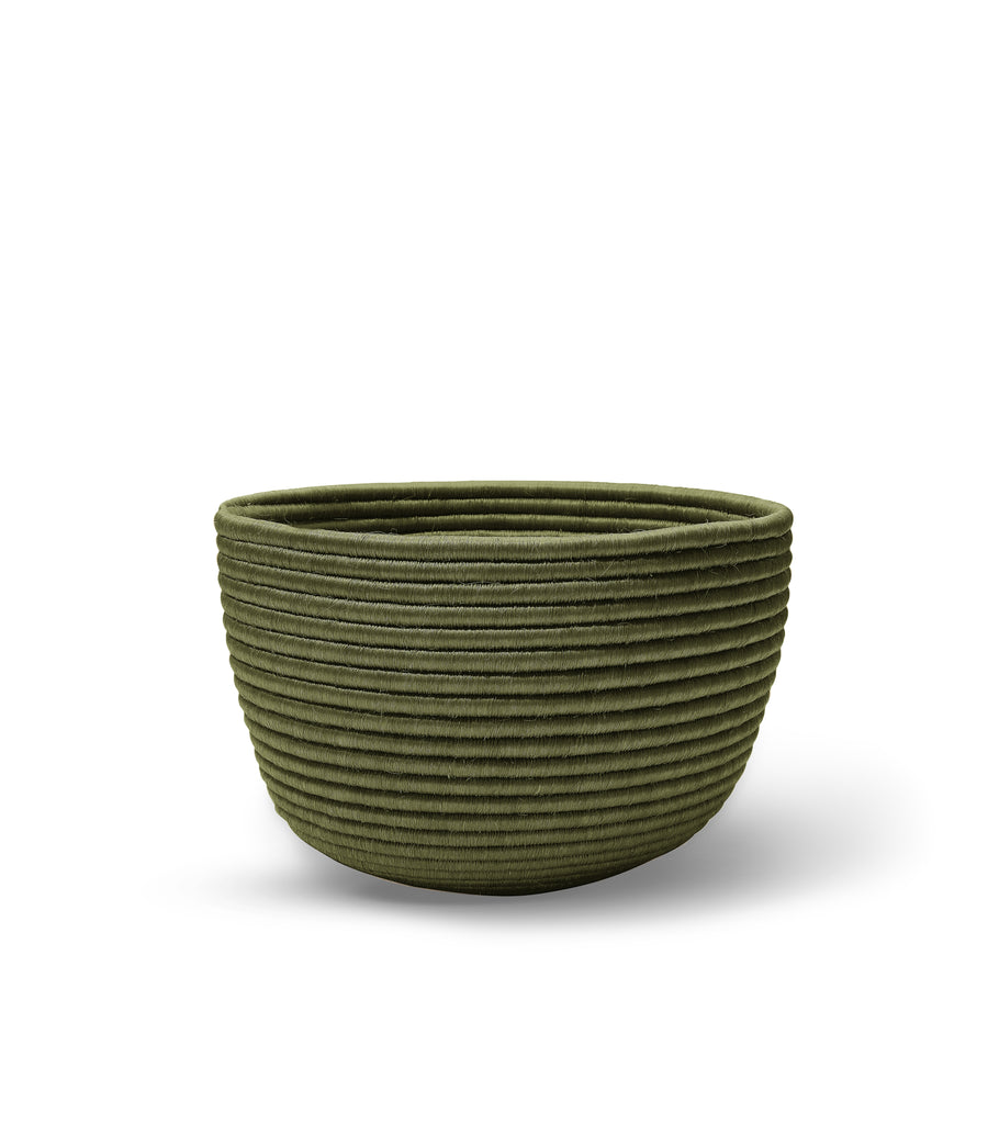 The Ames La Che Basket by Ames is a green, round bowl with a ribbed, textured surface made from Fique fibers, shown on a white background.
