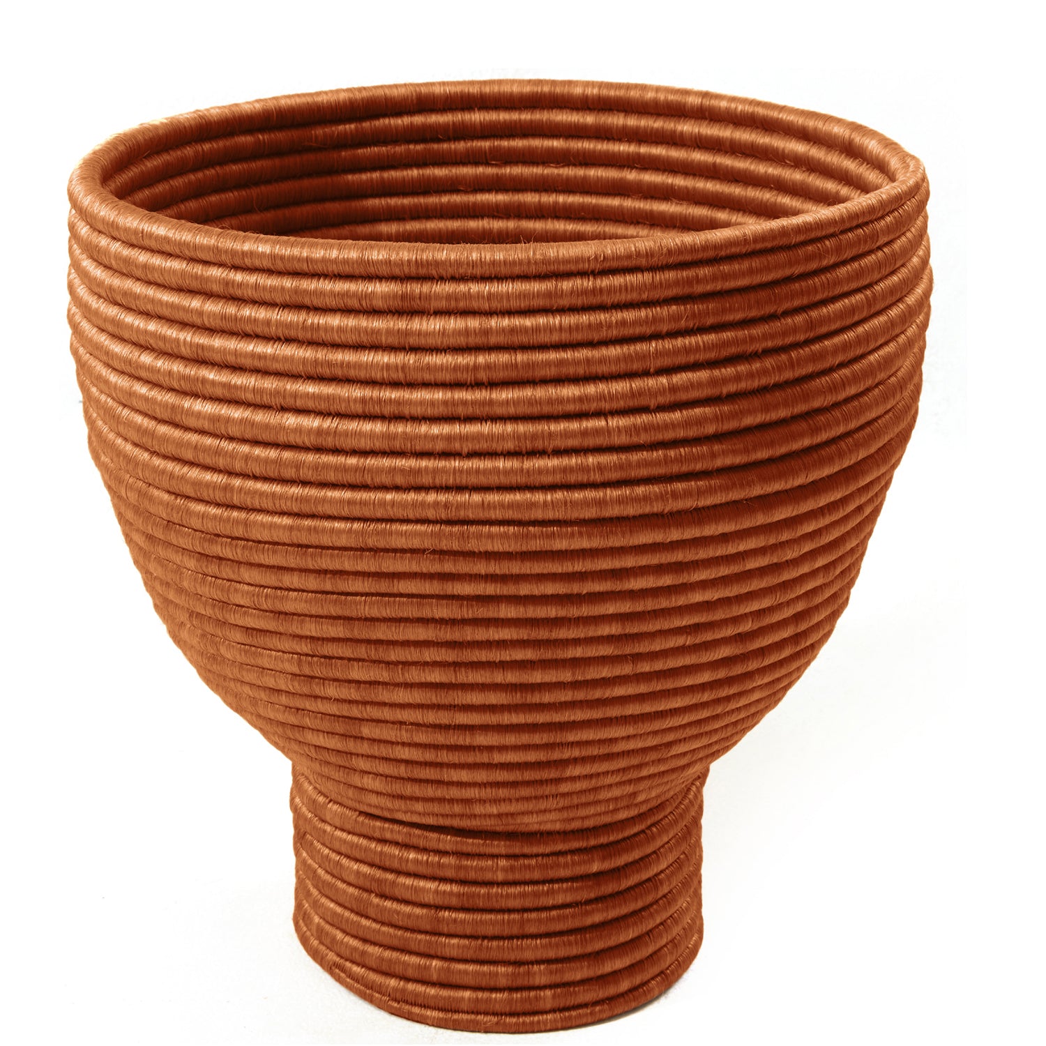 The Ames La Che Pot by Ames is a large, handcrafted bowl with a wide rim and narrow base, made from tightly coiled reddish-brown fique fiber for a textured look. The empty bowl is displayed against a white background.