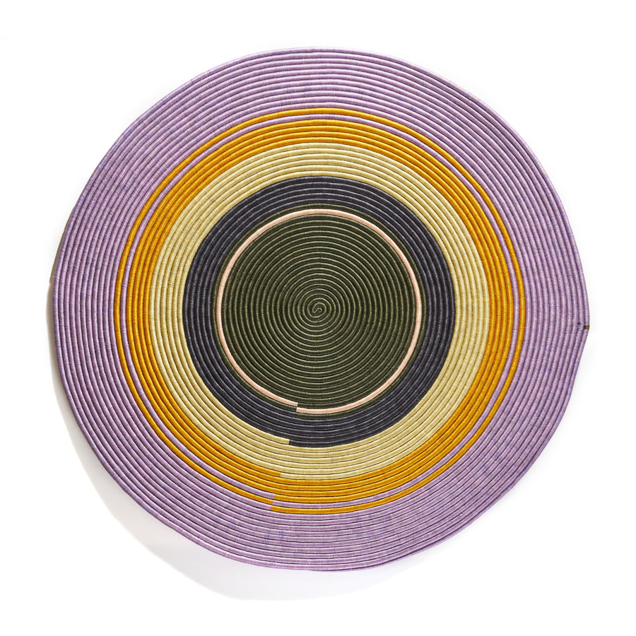 The Ames Ojitos Wall Decoration Andes by Ames features concentric rings in purple, yellow, white, black, and green on a circular woven lid made from fique palm fibers, creating a colorful geometric pattern.