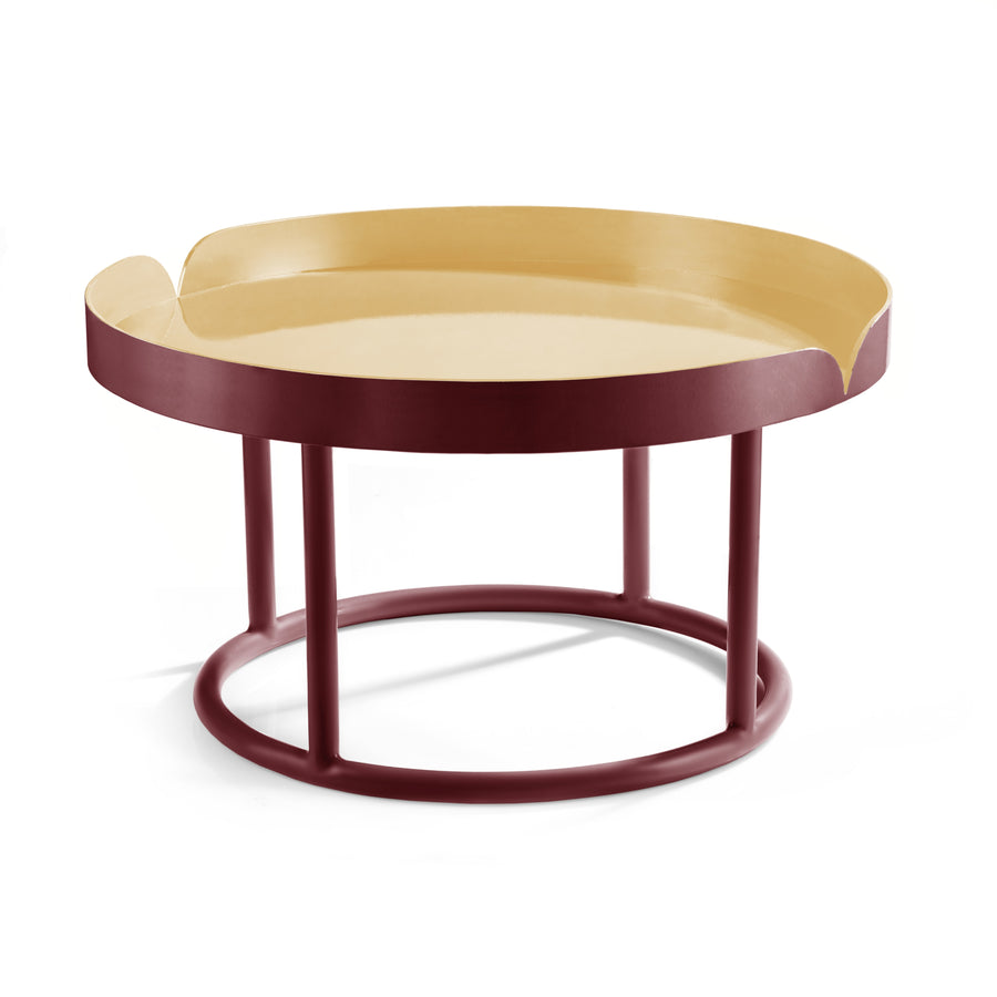 The Ames Victorias Coffee Table 1 by Ames is a round table inspired by Amazonia furniture, with a beige top, raised maroon edges, and four maroon legs joined by a circular base.
