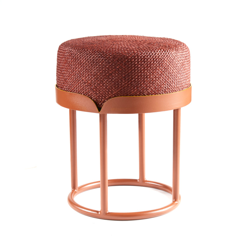 The Ames Victorias Pouf by Ames features a round, woven red-brown cushion atop a matching metal frame with three cylindrical legs, inspired by Amazonia furniture and victorias side tables, shown against a white background.