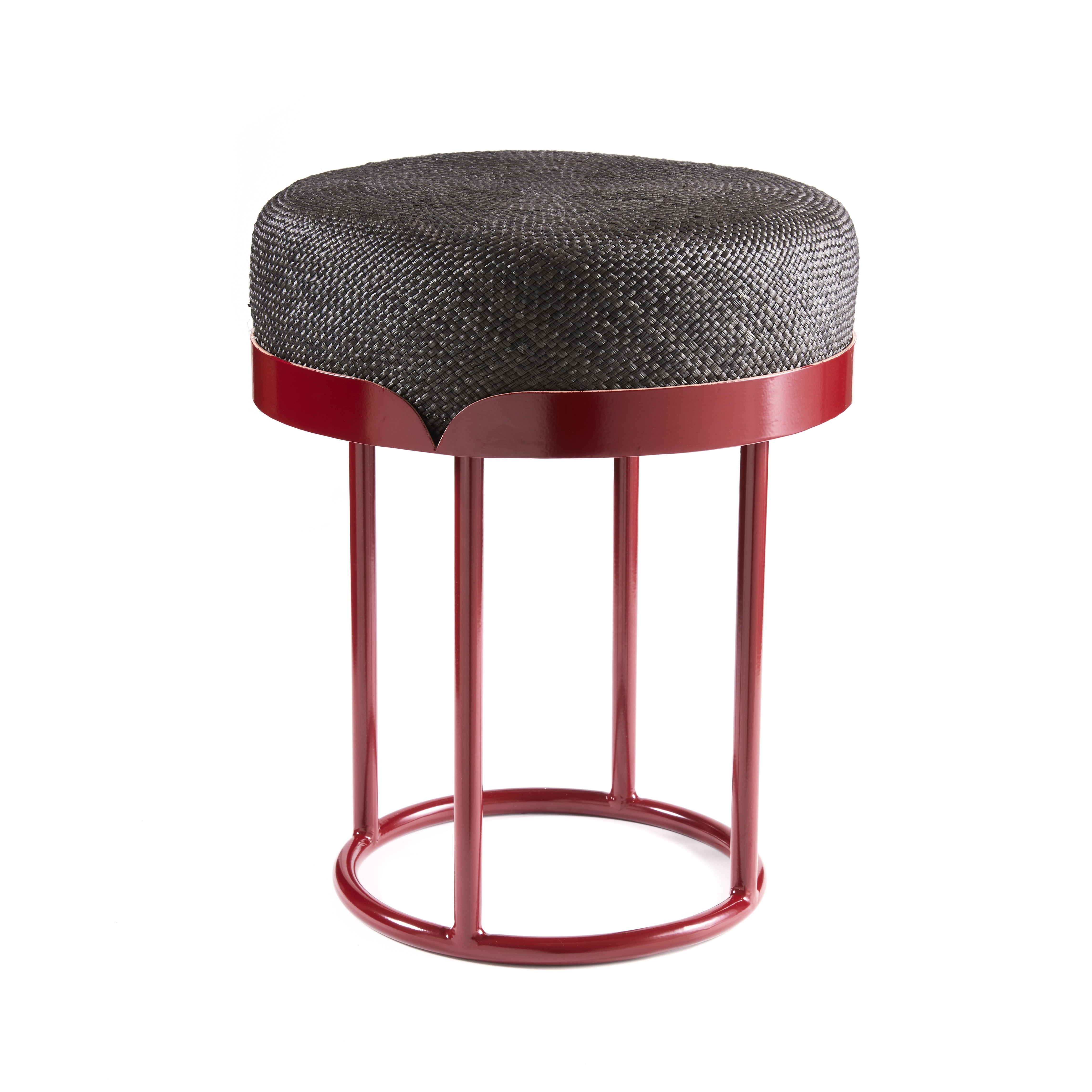 The Ames Victorias Pouf by Ames is a round stool inspired by Amazonian furniture, featuring a woven dark gray cushion seat and a red three-legged metal frame with a circular base, shown on a white background.