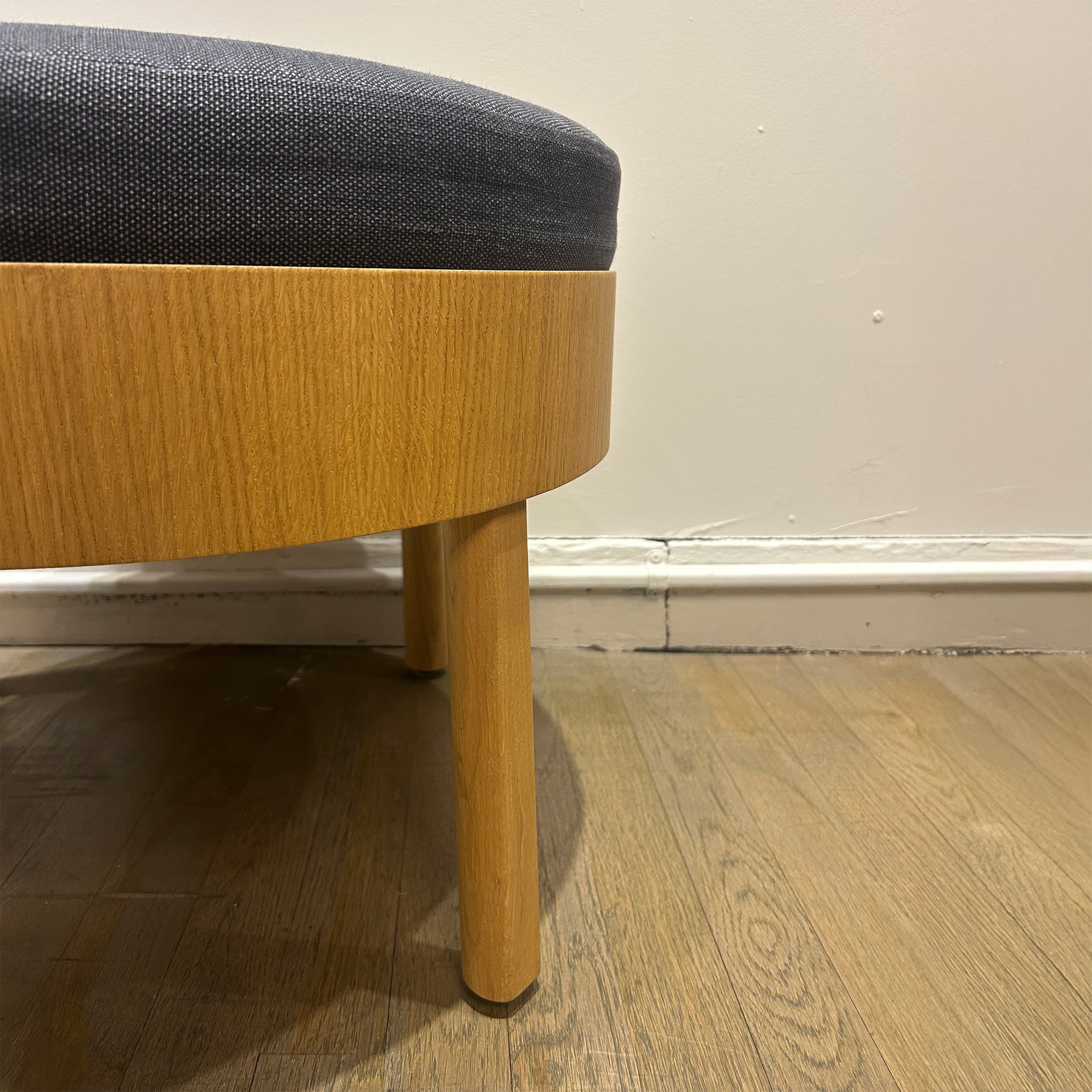 EC02 BESSY Stool close-up showing oak-veneered plywood frame with clear lacquer and dark upholstered round seat.