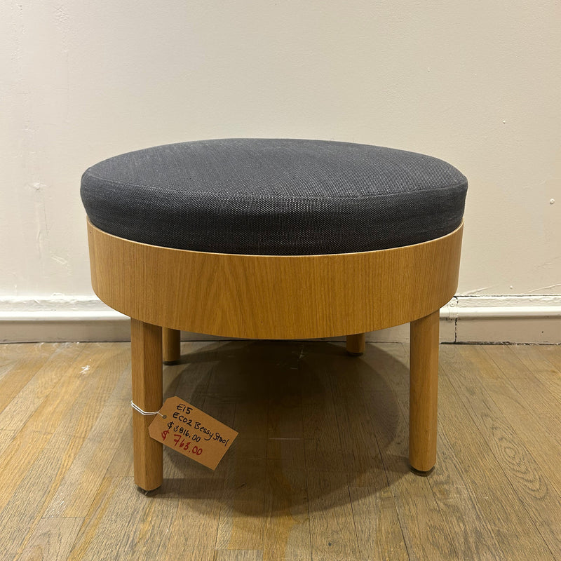 EC02 BESSY Stool with oak-veneered plywood base and round upholstered gray seat on wooden floor for sale at $745.00