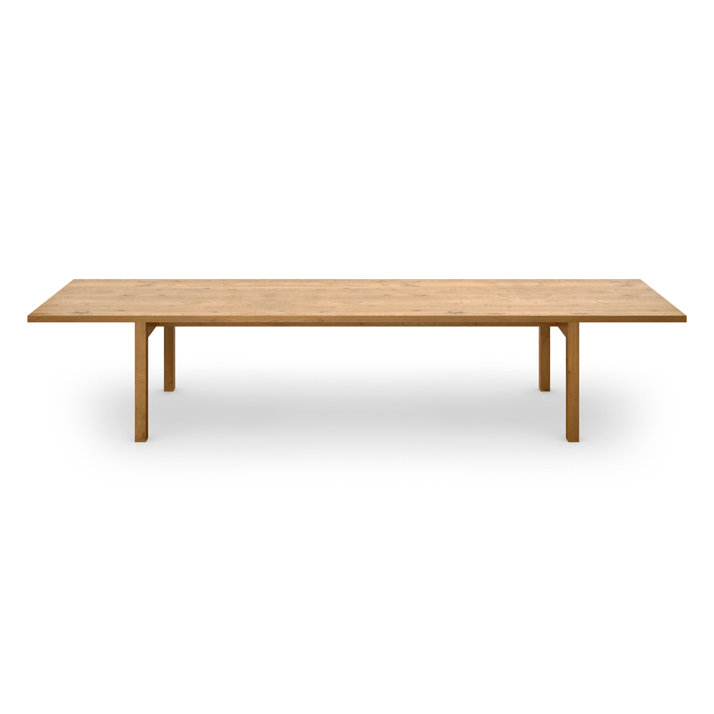 The DC09 Galerie by E15 is a long, rectangular solid oak table with a minimalist design, featuring four simple legs and a smooth surface. Positioned against a plain white background, it embodies the simplicity and elegance reminiscent of the Neue Nationalgalerie table.
