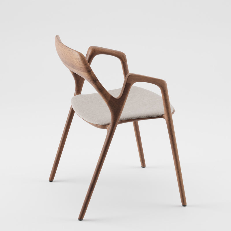 The Ging Chair by Artisan is a modern wooden chair crafted from solid wood with a curved backrest and armrests, featuring a light gray cushioned seat. It boasts a sleek, minimalist design against a white background.