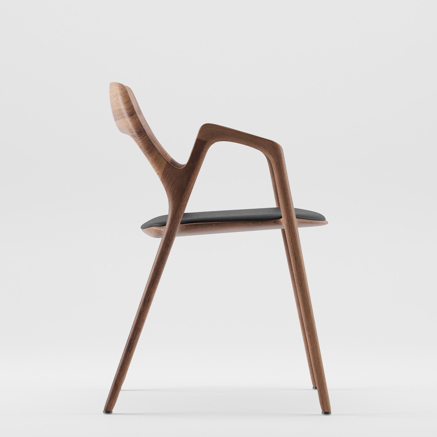 Side view of the Ging Chair by Artisan, a modern minimalist design in solid wood with a curved backrest and black cushioned seat, elegantly showcased against a white background.
