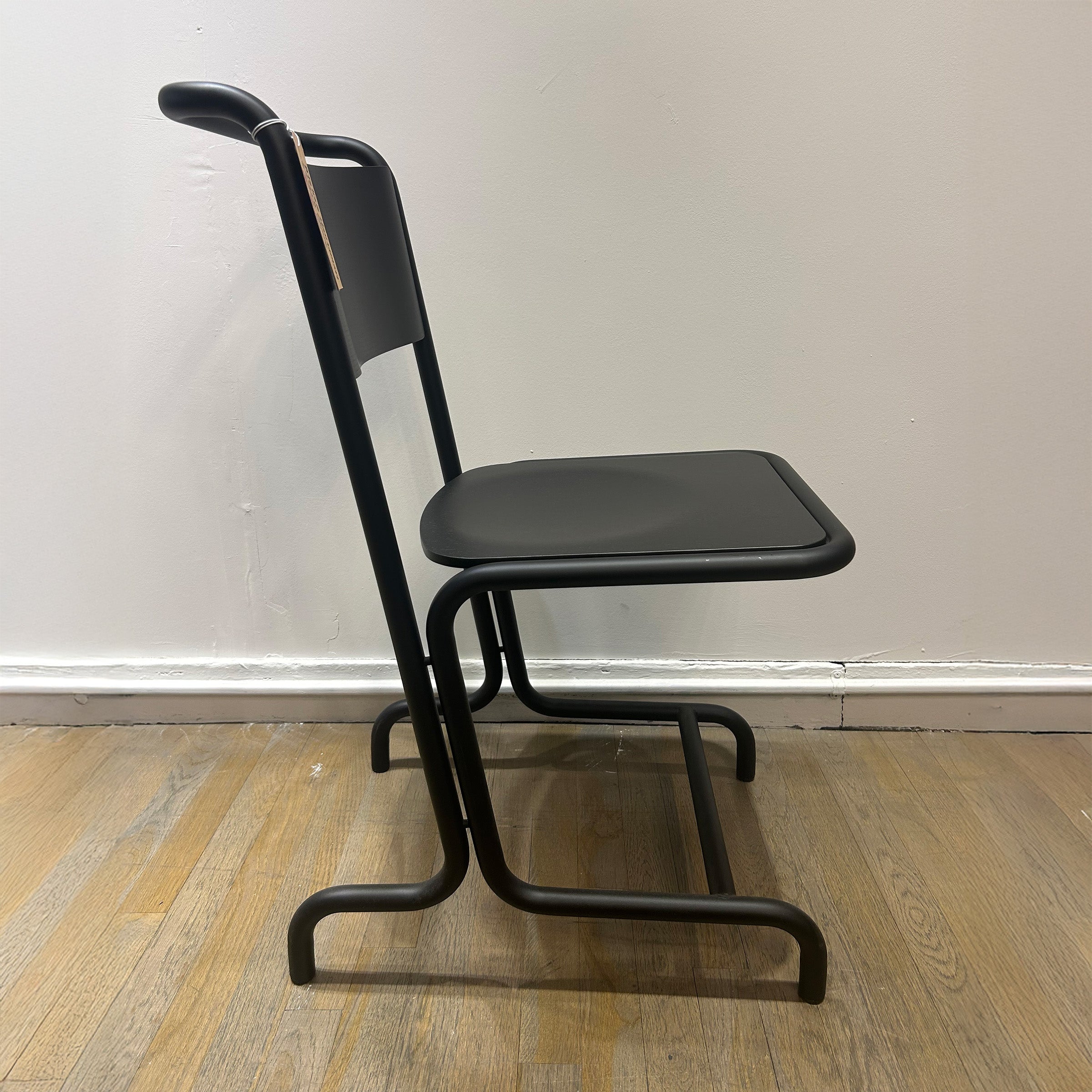 László Chair - Sale black cantilever steel tube and plywood chair with curved design and no front legs for comfort seating.