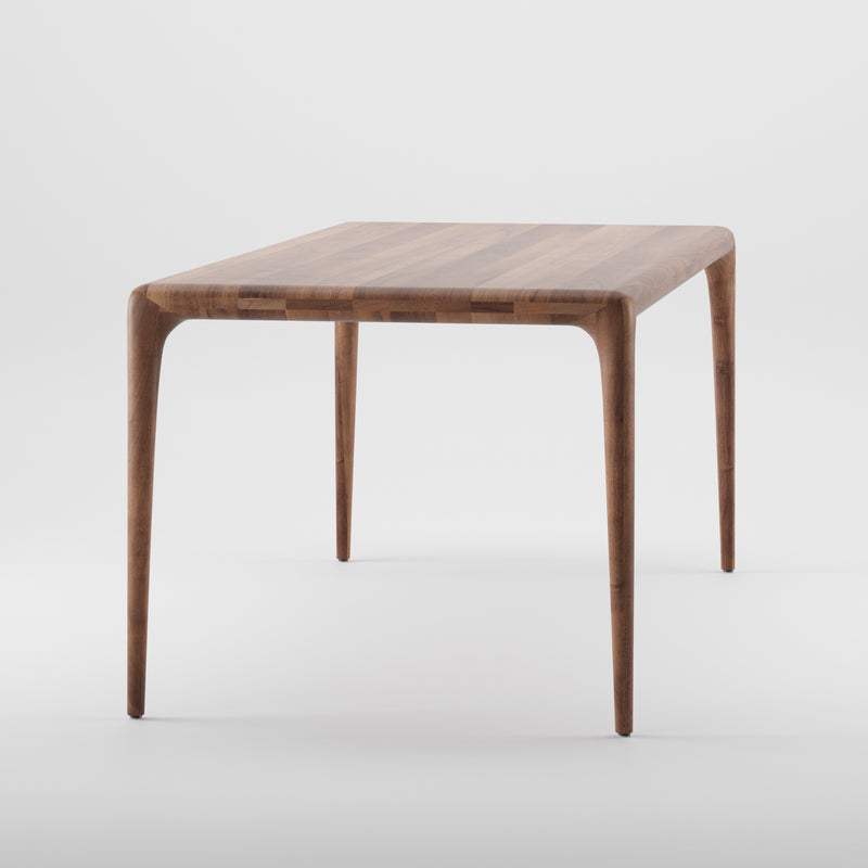 The LATUS Table by Artisan is a wooden table with a rectangular top and tapered legs, made from solid wood and finished with natural oils for smoothness, set against a plain white background.