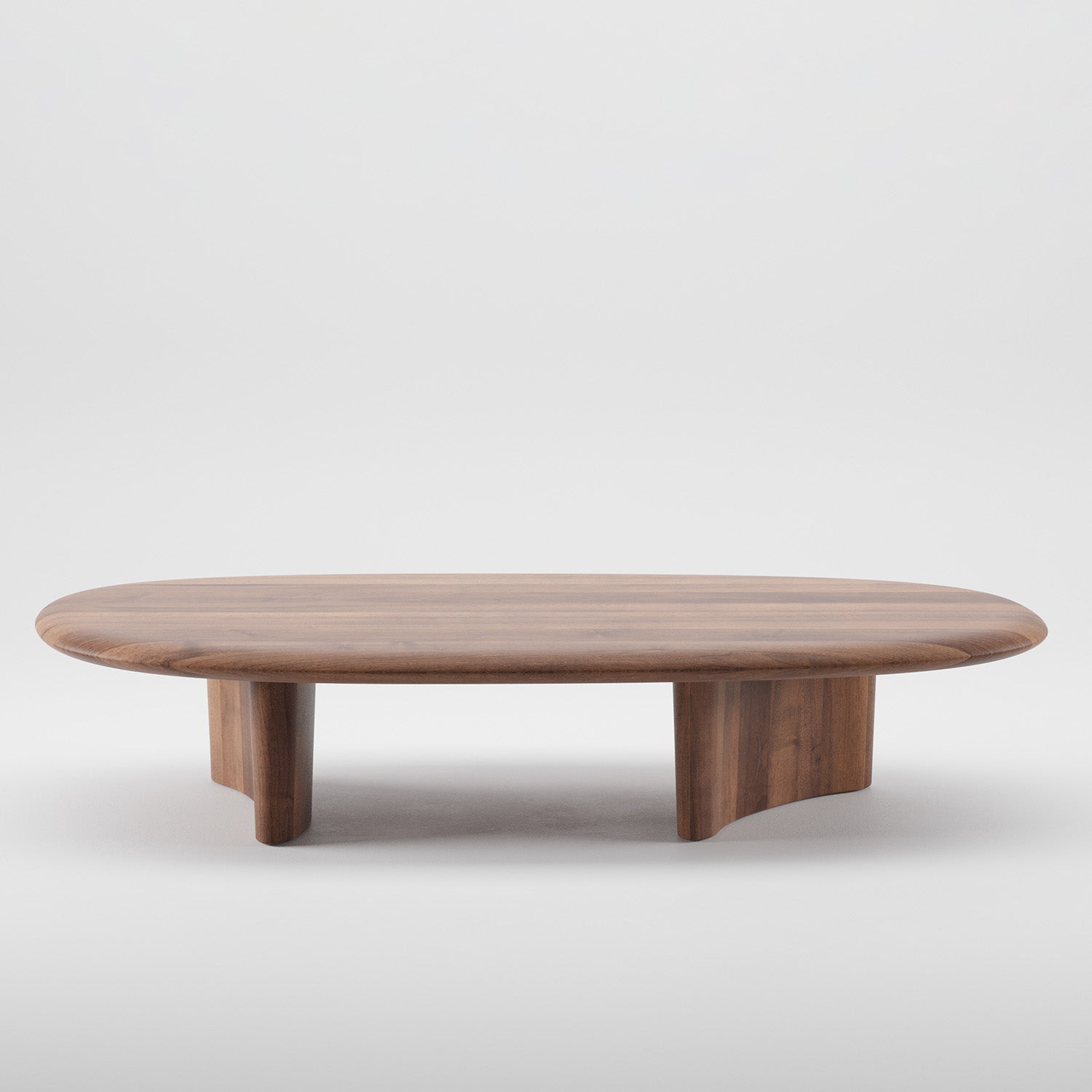 The Artisan MONUMENT Oval Coffeetable is a sleek, solid wood table with a smooth surface and rounded edges. Its minimalist design features two sturdy legs and a natural wood finish enhanced by eco-friendly oils, all set against a plain white background.