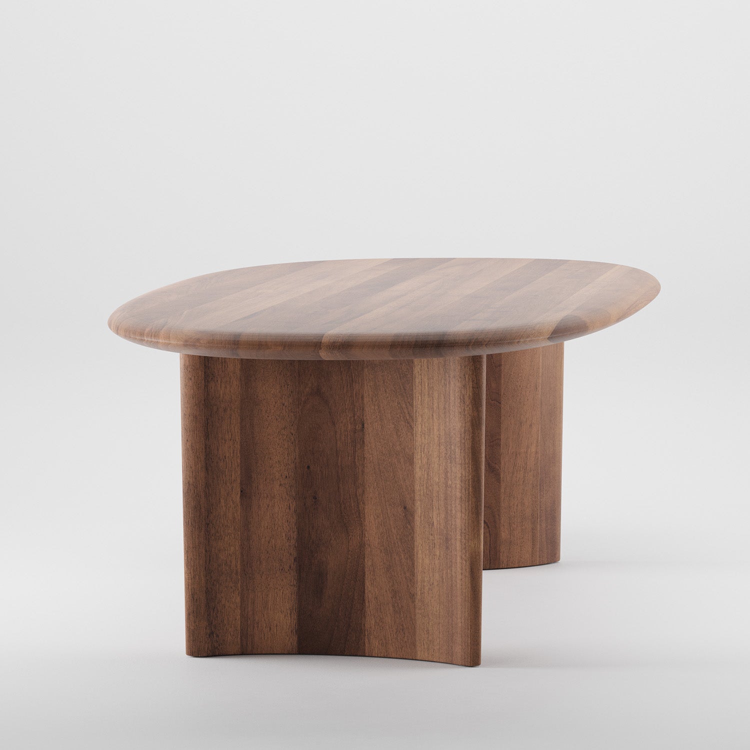 The Artisan MONUMENT Oval Table is a modern wooden coffee table with a curved top and vertical supports, crafted from solid wood. Treated with natural oils for an eco-friendly finish, its smooth surface highlights the wood grain beautifully against a plain white background.