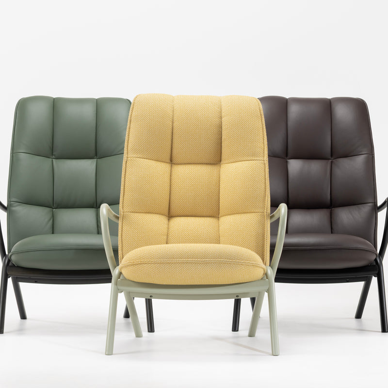 Three Cissy Lounge Chair High-Back models in yellow fabric, green, and dark brown leather upholstery on display.