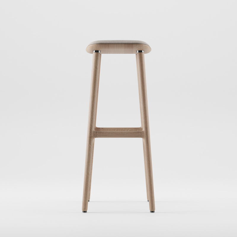 The NARU Barstool by Artisan is a minimalist masterpiece made from solid wood, featuring a smooth flat seat and slender legs. Its sleek design, set against a white background, showcases the luxurious wood texture and contemporary style.