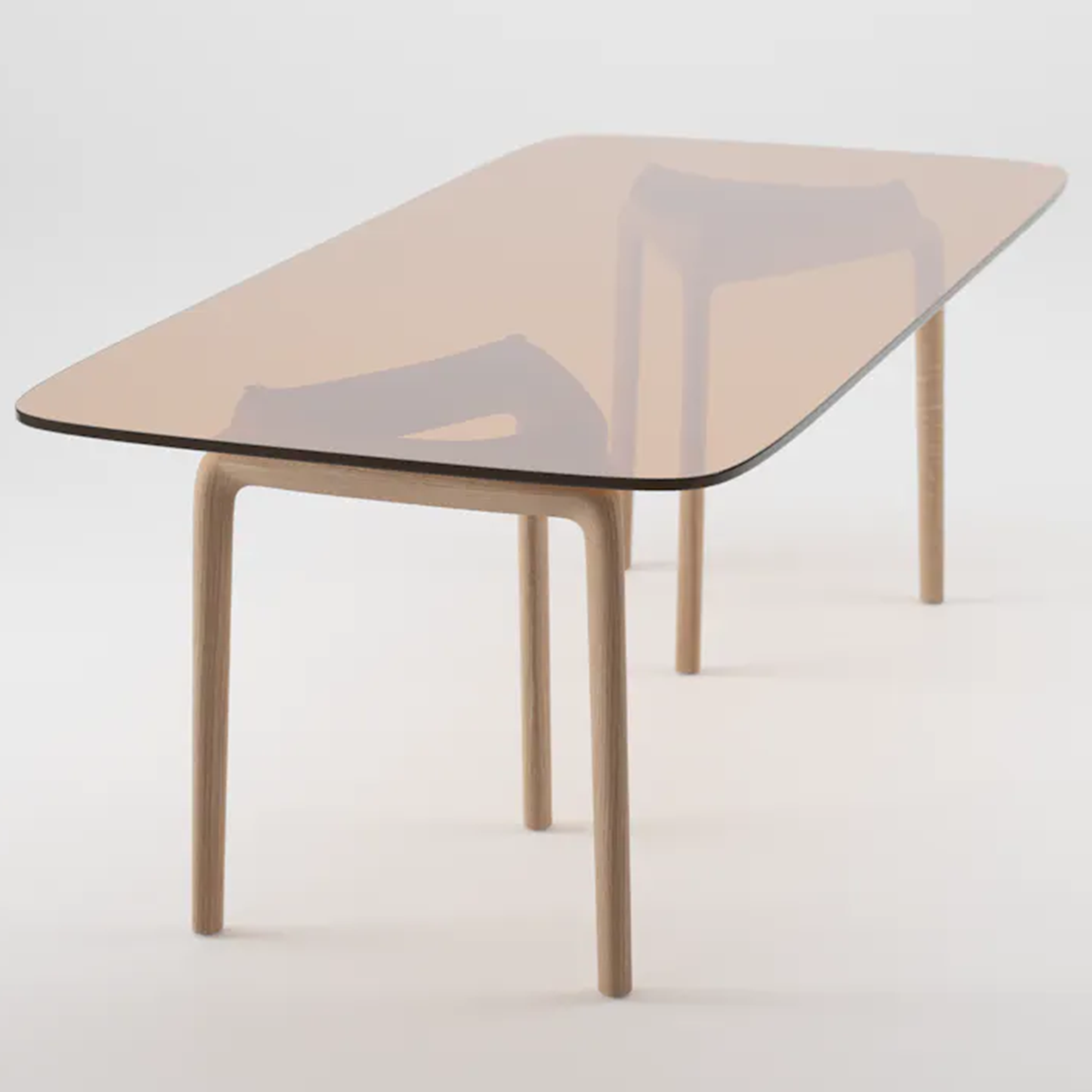 The PASCAL Rectangular Table by Artisan features a transparent glass top and light wooden legs made from solid wood. The glass reflects the legs for a subtle mirrored effect, blending minimalist design with both functionality and aesthetics while highlighting the natural wood texture.